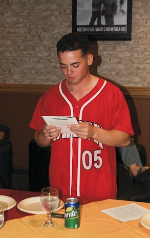 Peter Alfis, Murder Mystery Dinner actor playing the baseball player, reads  clues about other murder suspects to the audience during the Murder Mystery Dinner held at the Single Marine Program Hornet’s Nest here Nov. 20, 2012.