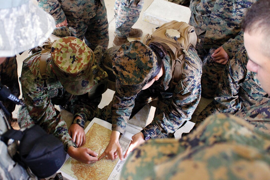 Service members with Headquarters and Service Battalion’s corporals course plot their grid points before beginning the land navigation course at the Jungle Warfare Training Center Nov. 28. 
