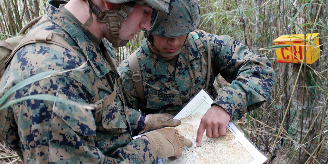 Lance Cpl. Andrew L. Elgin and Cpl. Chazz R. Peters verify their grid points during the land navigation course at the Jungle Warfare Training Center Nov. 28. Elgin is a military policeman with Headquarters and Service Battalion, Marine Corps Base Camp Butler, and Peters is a telephone systems personal computer repairer with Combat Logistics Regiment 35.