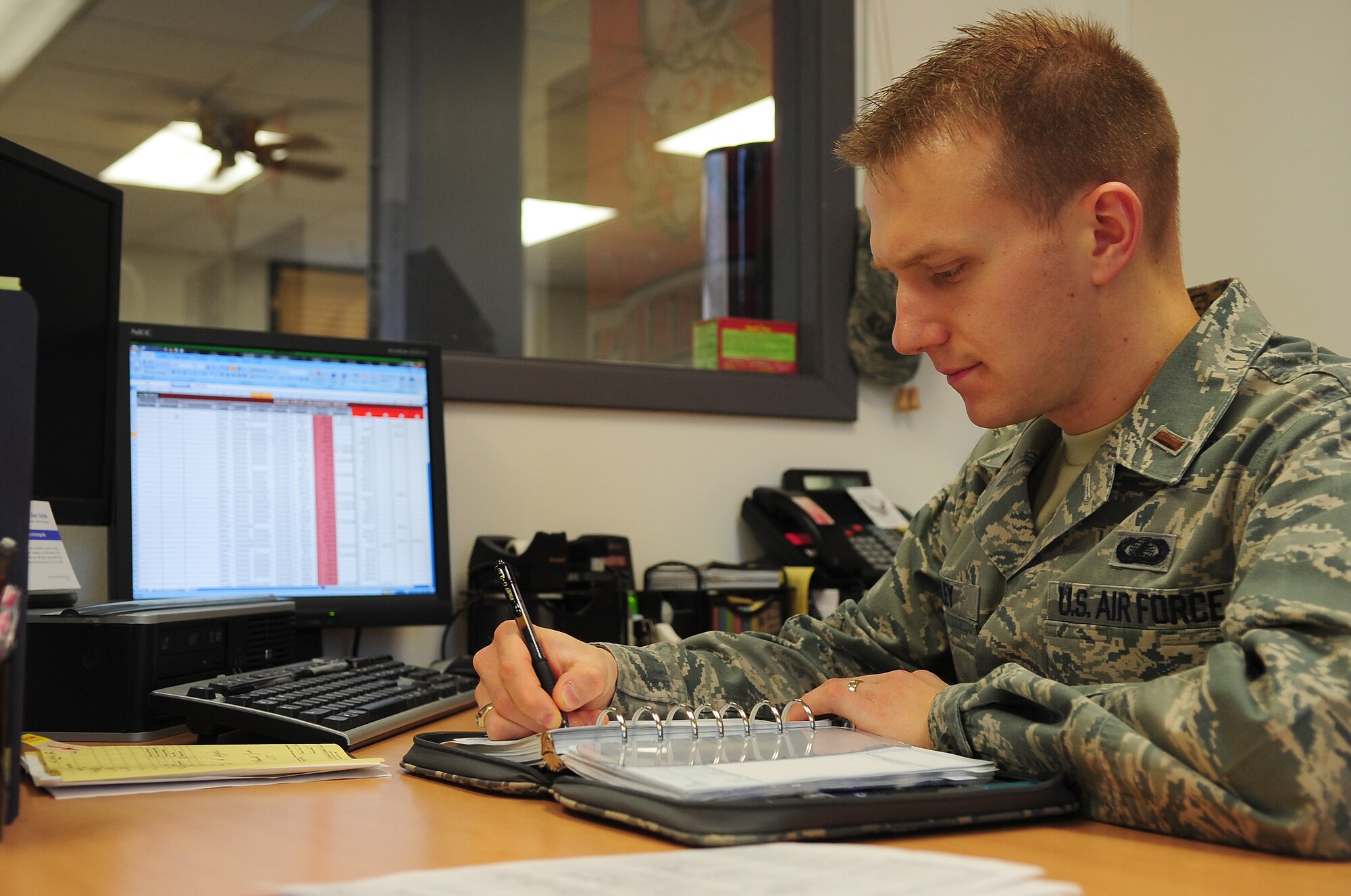 U.S. Air Force 2nd Lt. Nicholas Gumley, 354th Comptroller Squadron financial services officer, reviews notes while preparing a financial spreadsheet Dec. 3, 2012, Eielson Air Force Base, Alaska. Gumley sings in the Fairbanks Symphony Chorus and recently performed in the holiday concert. (U.S. Air Force photo/Airman 1st Class Zachary Perras)