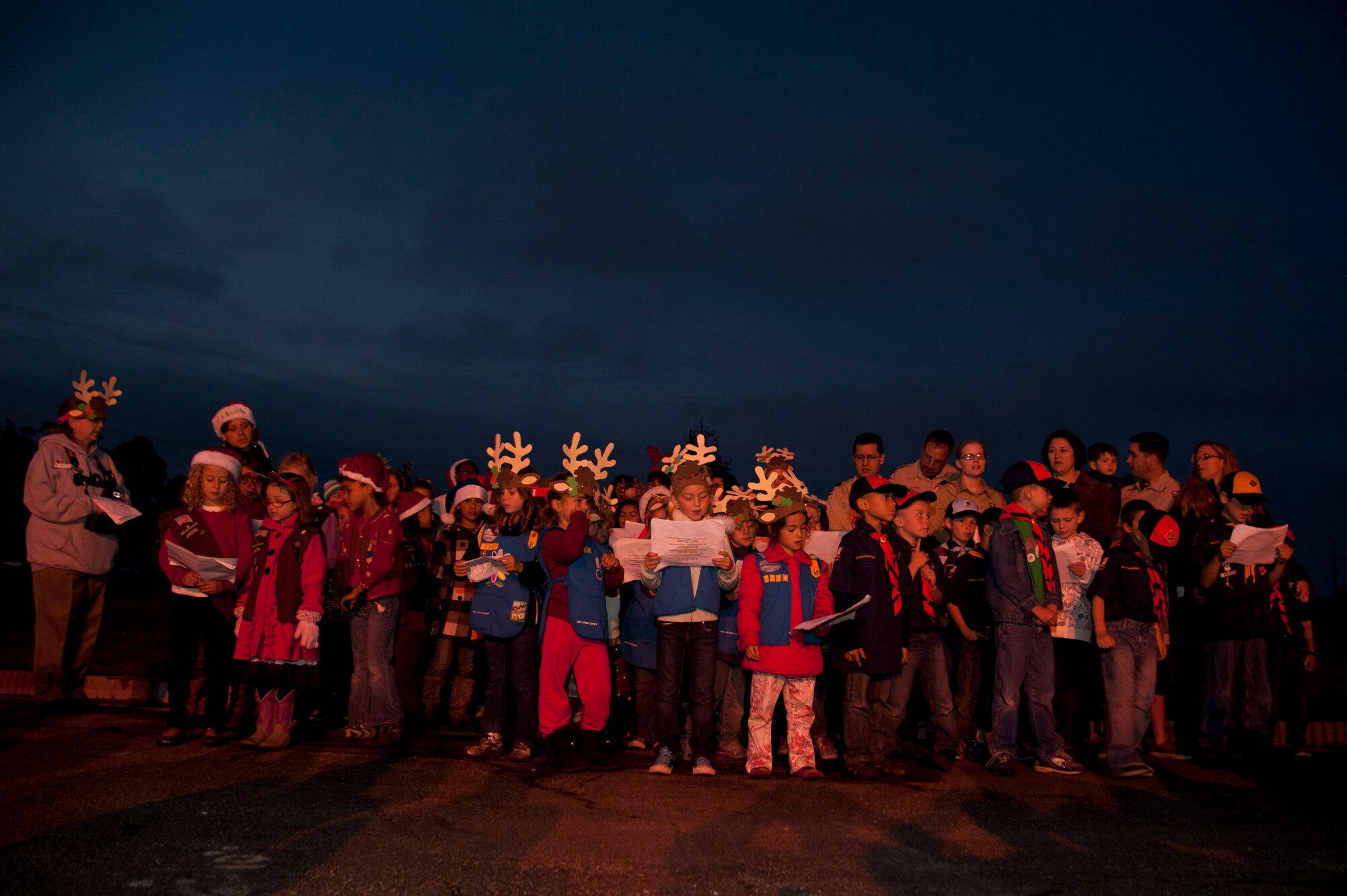 VANDENBERG AIR FORCE BASE, Calif. – Vandenberg Girl Scouts and Cub Scouts sing carols to get the crowd in the holiday spirit during the annual Tree Lighting Ceremony in front of building 11777 here Tuesday evening, Dec. 4, 2012. The event included caroling, hot chocolate, the lighting of the tree and a visit from Santa Claus. (U.S. Air Force photo/Senior Airman Lael Huss)