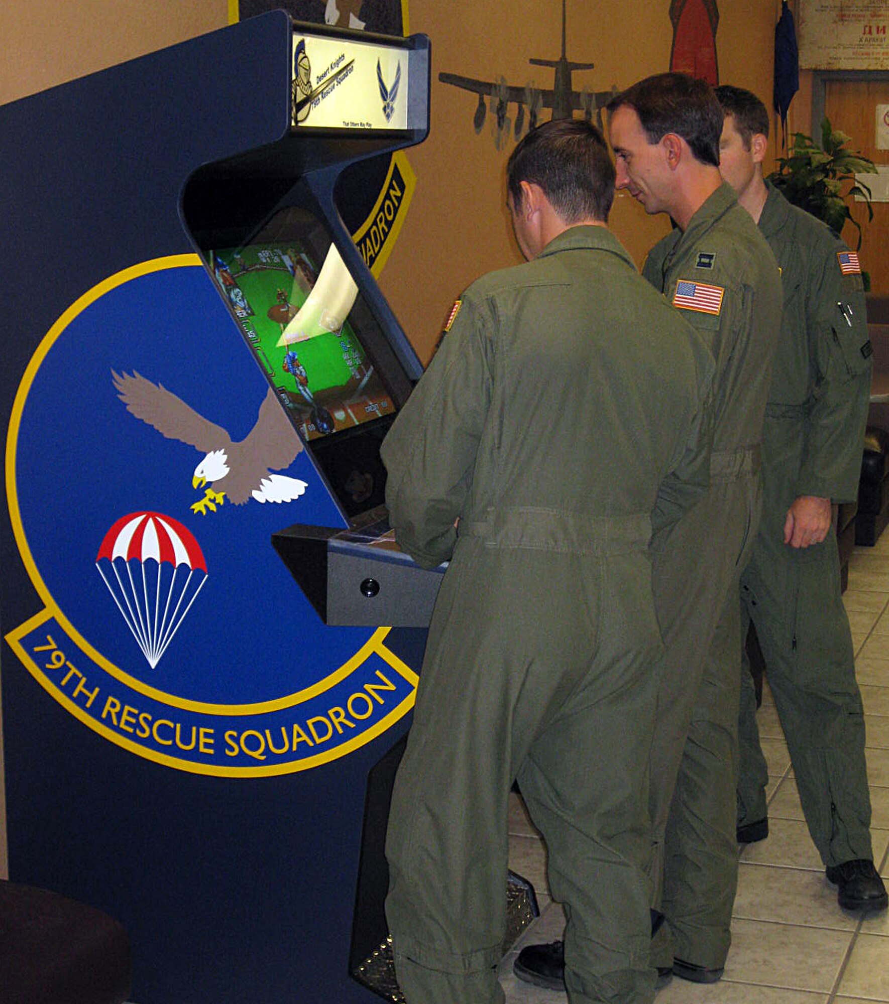 U.S. Air Force Airmen assigned to the 79th Rescue Squadron play a game on a personalized arcade machine. Tech. Sgt. Melvin Clem built and designed the machine with the squadron in mind. (Courtesy photo/Released)