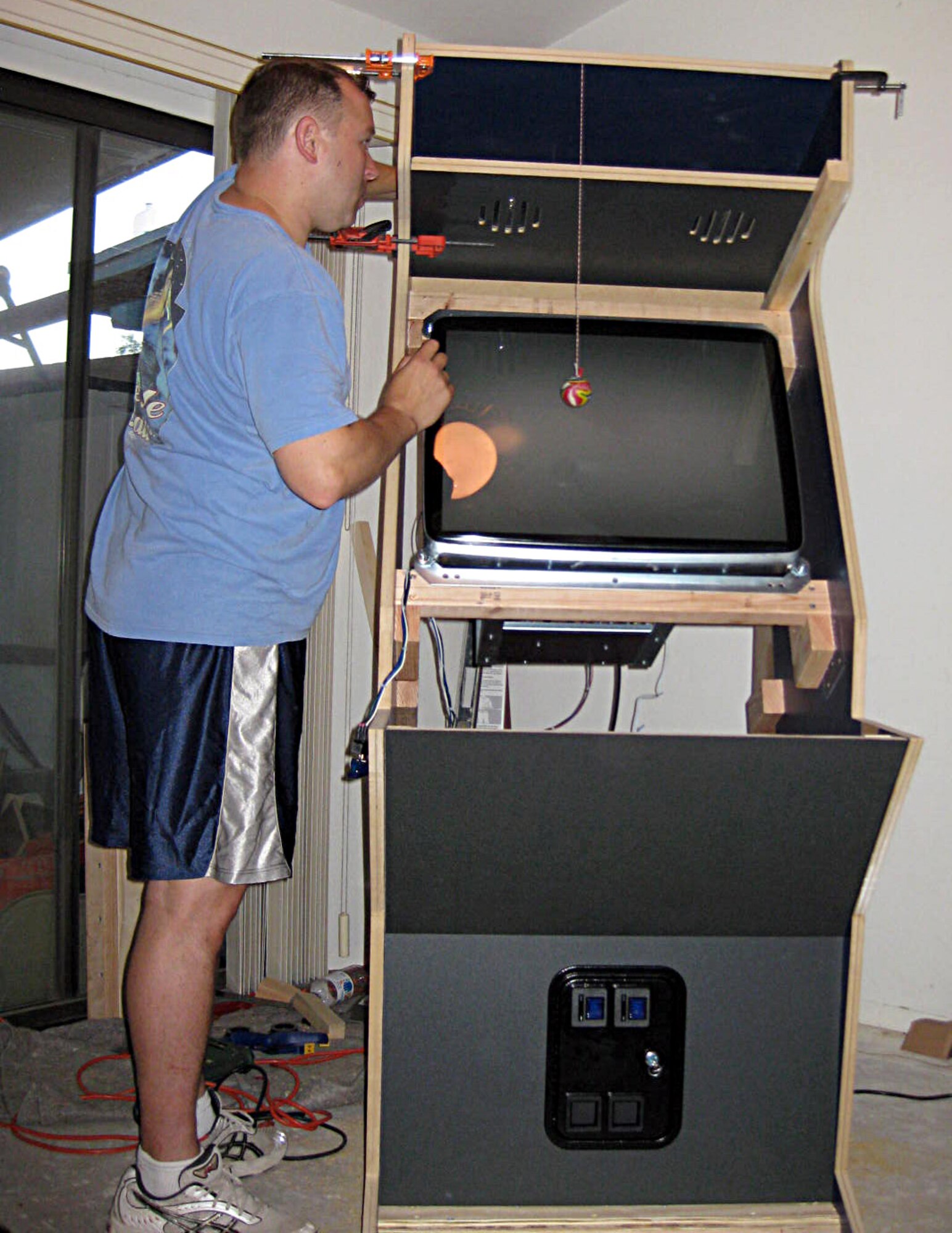 U.S. Air Force Tech. Sgt. Melvin Clem, 355th Force Support Squadron Airman Leadership School executive assistant, makes adjustments to the frame of his personalized arcade machine. Clem used skills he learned from the Air Force to create the machine. (Courtesy photo/Released)