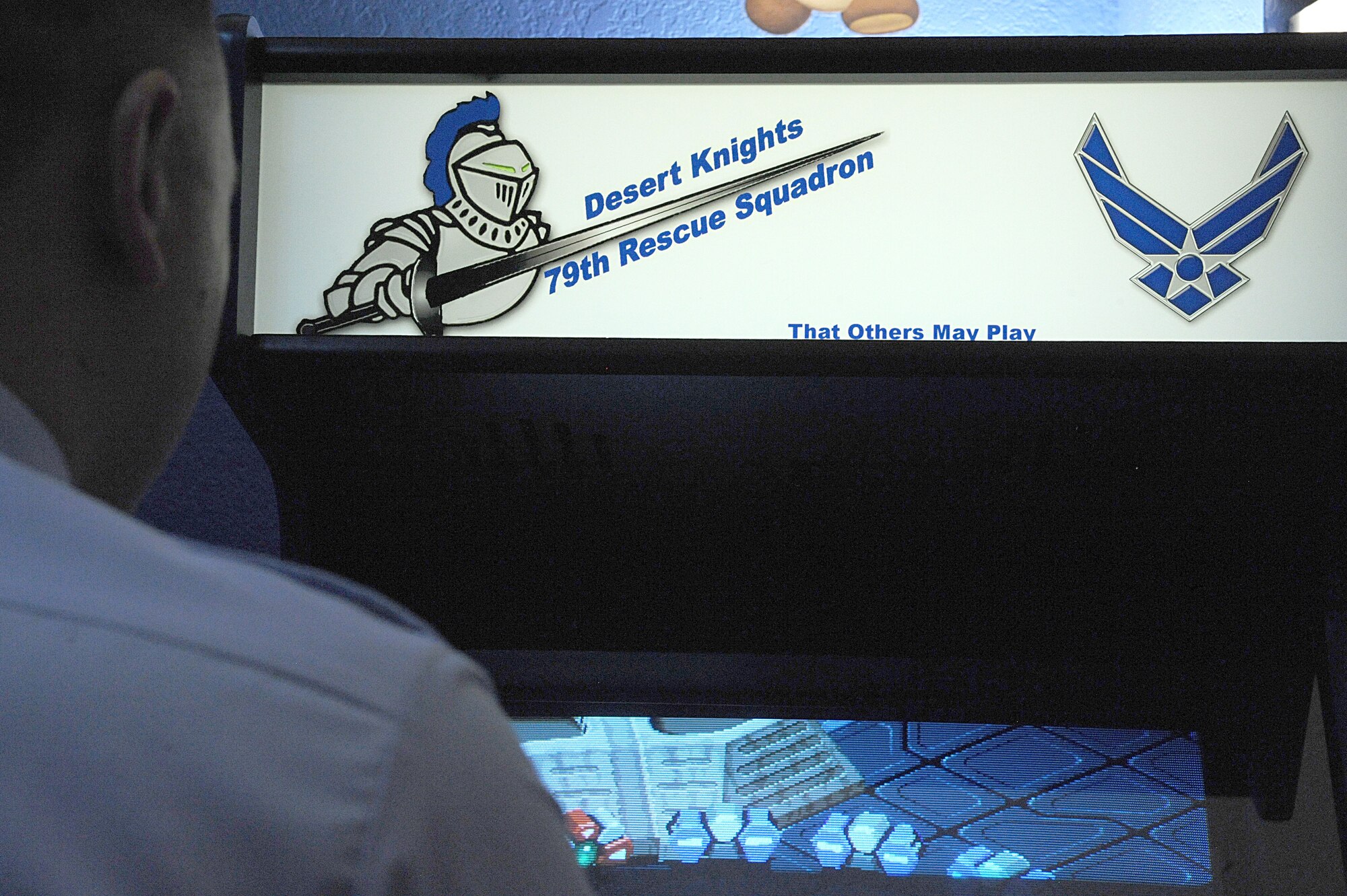 U.S. Air Force Tech. Sgt. Melvin Clem, 355th Force Support Squadron Airmen Leadership School executive assistant, plays a game on his personal arcade machine at his home in Tucson, AZ, June 25, 2012. Clem designed and made the arcade himself. The words on the front are play on the 79th Rescue Squadron's motto: "That others may live." (U.S. Air Force photo by Senior Airman Timothy Moore/Released)