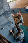 Col. Mark Weatherington (right), 28th Bomb Wing commander, and Chief Master Sgt. Kevin Peterson, 28th BW command chief, climb the newly-installed rock climbing wall in the Pride Hangar on Ellsworth Air Force Base, S.D., Dec. 3, 2012. The wall will be officially available for use on Dec. 17, and climbers must have a member trained on how to oversee climbing activities present at all times to ensure safety. For scheduling and more information, call Outdoor Recreation at (605) 385-2996. (U.S. Air Force photo by Airman 1st Class Kate Thornton-Maurer/Released)