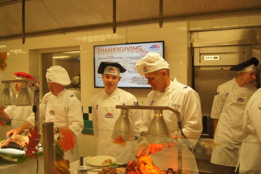 (From left) Col. Dann Carlson, 647th Air Base Group commander, and Col. Johnny Roscoe, 15th Wing commander, serve food during a Thanksgiving Meal Nov. 22 at the Hickam Dining Facility on Joint Base Pearl Harbor-Hickam, Hawaii. Base leaders and spouses took time to serve food to base Airmen during the holidays. (Courtesy photo)