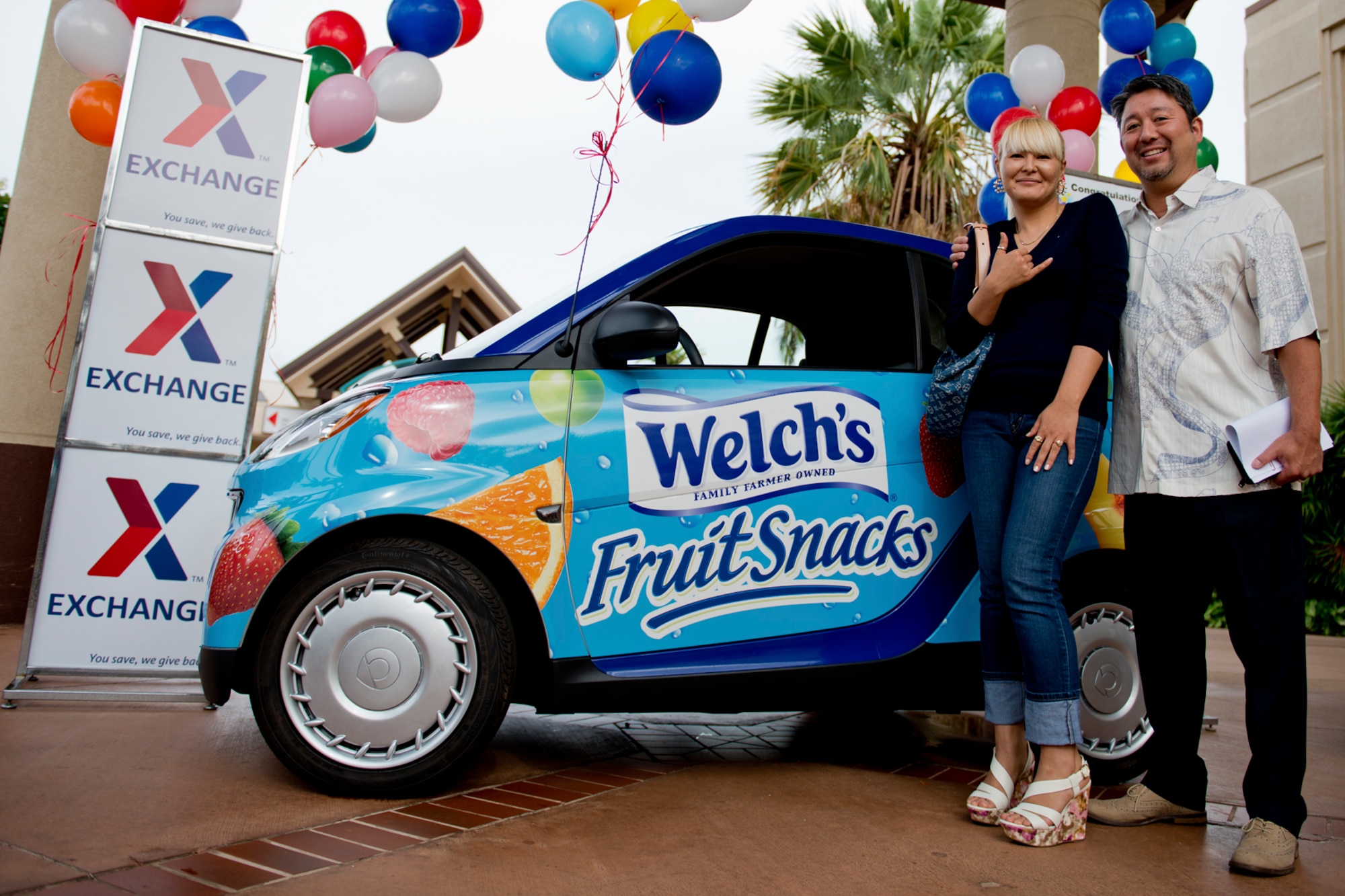 Nurjan Sakagawa and Master Sgt. (Ret.) Ryan Sakagawa, stands by the Smart Car she won during an Army Air Force Exchange worldwide drawing where tens of thousands of entrants vied for the Promotion-in-Motion Sweepstakes. She and her husband were presented the car, keys and title at the Hickam Field Base Exchange Nov. 29, 2012. “I couldn’t believe it,” she said elated that she no longer has to ride a public transit bus from downtown Honolulu to the base to shop for groceries or at the exchange. “It’s hard to carry all of those bags on the bus, so I had to get things a little at a time. Now I can shop more.” (U.S. Air Force photo/Staff Sgt. Mike Meares)