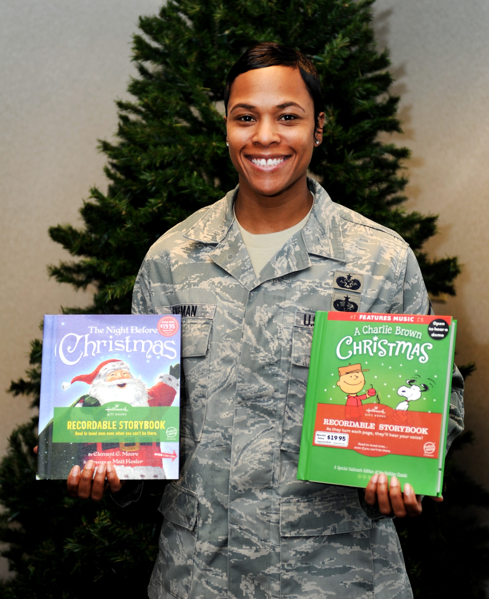Master Sgt. Kimberly Freeman, Airman and Family Readiness Center, shows two recordable books family members can pick up from the AFRC and send to deployed family members for the holidays. (U.S. Air Force photo/Staff Sgt. Maria Bowman)