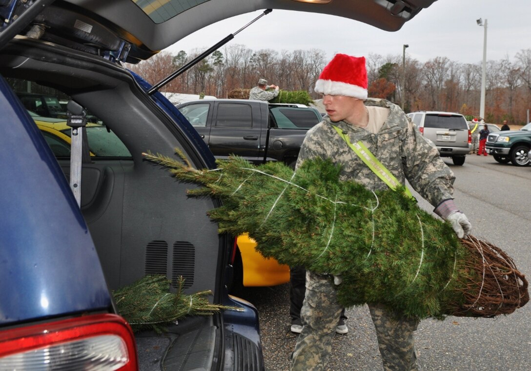 U.S. Army Pvt. Kyle Anderson, a Soldier assigned to the 1-222nd Aviation Regiment, loads a Christmas tree into a customer's vehicle at the annual “Trees for Troops” Christmas Tree giveaway at Fort Eustis, Va., Dec. 5, 2012. Trees were distributed first come, first served to Service members and their families free of charge, made possible by donations from patrons of two Christmas tree farms. (U.S. Air Force photo by Senior Airman Jason J. Brown/Released)