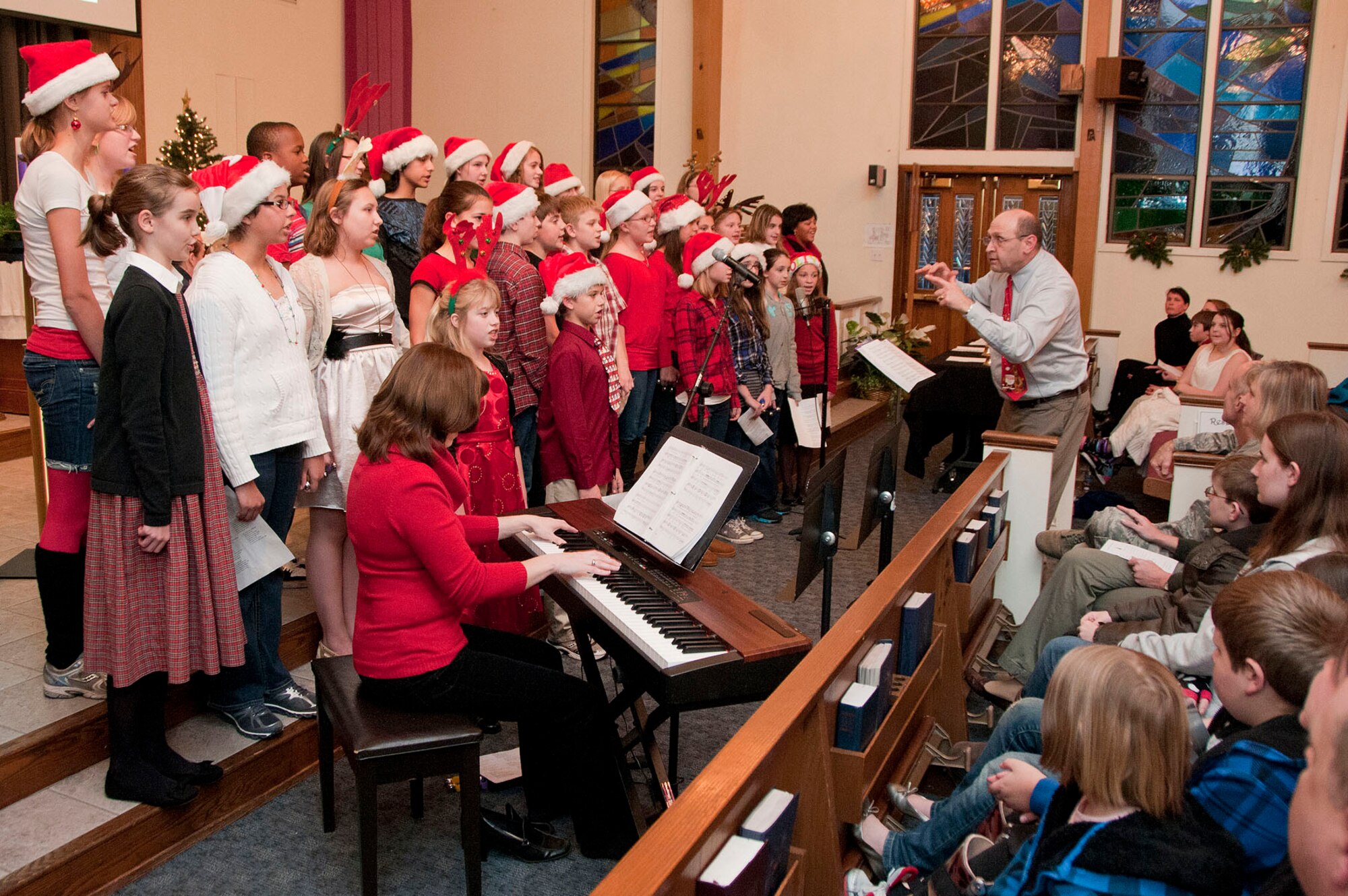 HANSCOM AIR FORCE BASE, Mass. -- The Hanscom Middle School Select Choir, directed by Howard Worona, performs during the Christmas Tree Lighting ceremony Dec. 4 at the base chapel. The event began with Christmas music, was followed by flipping the switch outside to light the tree and ended with the arrival of Santa Claus on a fire truck. (U.S. Air Force photo by Mark Wyatt)