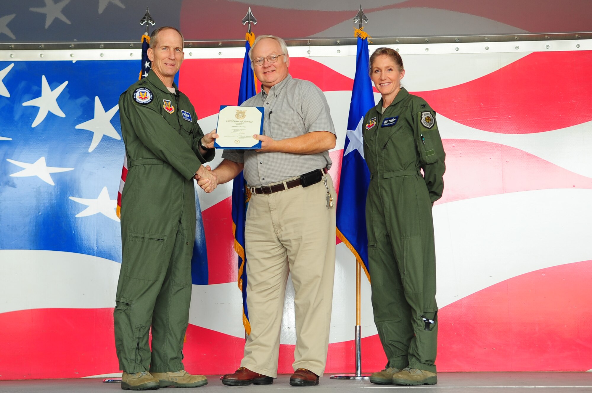 U.S. Air Force Gen. Mike Hostage, Commander, Air Combat Command, and Col. Jeannie Leavitt, 4th Fighter Wing commander, present a 40-year Length of Service Certificate to Danny Sellers, 4th Civil Engineer Squadron alarm system technician, on Seymour Johnson Force Base, N.C., Dec. 4, 2012. Hostage highlighted two Department of Defense civilian employees for their service to the Air Force in front of more than 500 members of Team Seymour. (U.S. Air Force photo/Airman 1st Class Aubrey White/Released) 