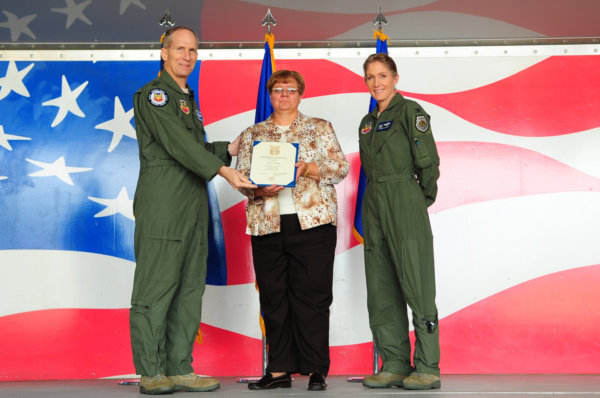 U.S. Air Force Gen. Mike Hostage, Commander, Air Combat Command, and Col. Jeannie Leavitt, 4th Fighter Wing commander, present a 40-year Length of Service Certificate to Clara Stewart, 4th Civil Engineer Squadron asset management flight secretary, on Seymour Johnson Force Base, N.C., Dec. 4, 2012. Hostage highlighted two Department of Defense civilian employees for their service to the Air Force in front of more than 500 members of Team Seymour. (U.S. Air Force photo/Airman 1st Class Aubrey White/Released)