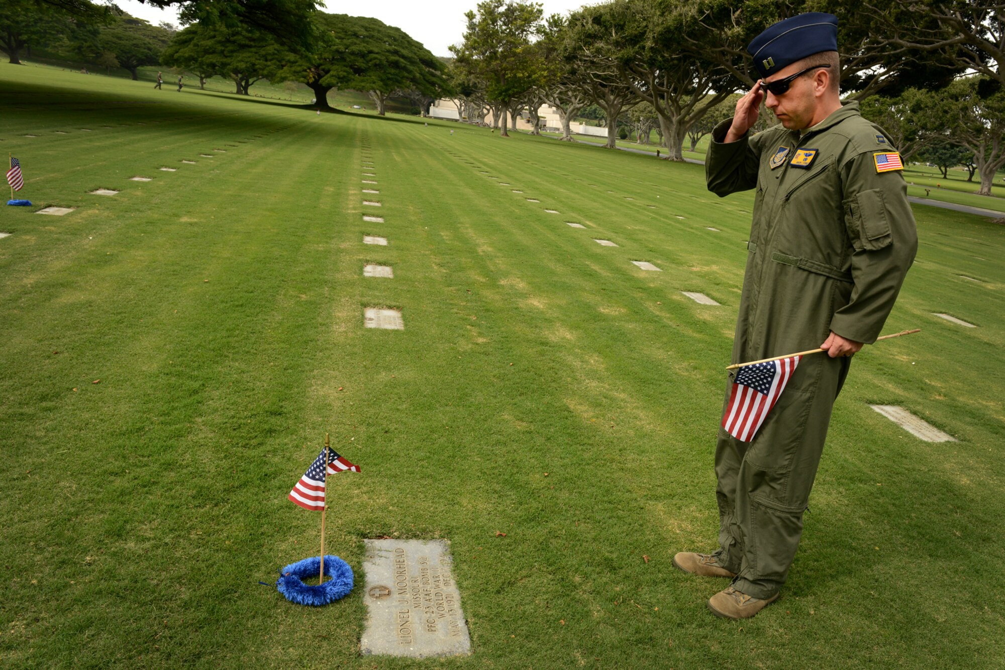 Capt. Andy Stewart, 15th Wing commander’s Action Group, salutes a gravesite after placing an American flag and handmade lei at the top, Dec. 2, 2012, at the National Cemetery of the Pacific, at Punchbowl in Honolulu. Stewart, and nine other volunteers placed 92 flags among the 34,000 gravesites on the grounds of the cemetery to honor the men who lost their lives at Hickam Field on Dec. 7, 1941. Stewart cleaned debris from each of the gravesites he placed a marker and saluted each Airman. (U.S. Air Force photo/Staff Sgt. Mike Meares)  