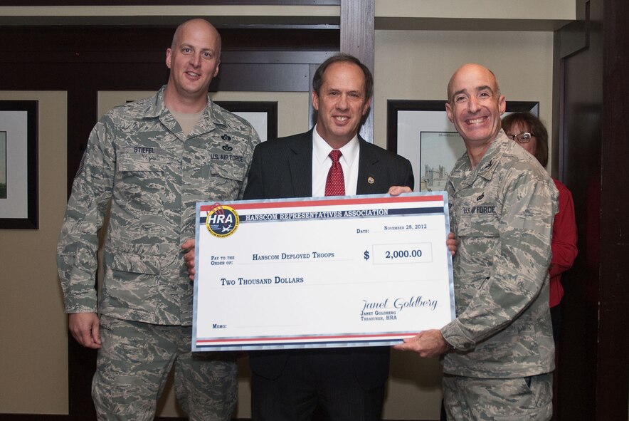 BEDFORD, Mass. – Bruce Hevey (center), Hanscom Representatives Association president, presents a check to Col. Lester A. Weilacher, 66th Air Base Group commander, and Chief Master Sgt. Baird Stiefel, 66th Air Base Group superintendent, at the HRA annual holiday party Nov. 28. The money will be used to support deployed Airmen and their families. (U.S. Air Force photo by Mark Herlihy)