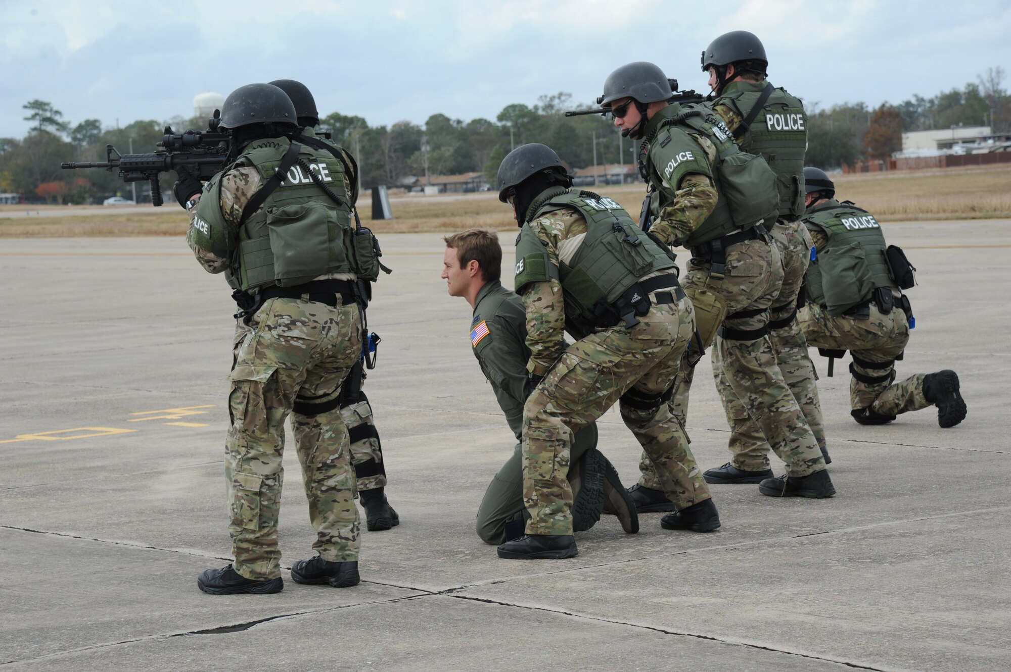Capt. Scott Boeckman, 53rd Weather Reconnaisance Squadron, portrays a hostage who is being apprehended for safety purposes by the Biloxi Police Department Special Response Team upon his release from the aircraft during an anti-hijacking exercise on the flightline at Keesler Air Force Base, Miss., Dec. 4, 2012. The exercise scenario consisted of a disgruntled Airman, who after being denied leave during the holidays, created a fake Air Force leave form to get on a flight and hijack the aircraft to fly home.  (U.S. Air Force photo by Kemberly Groue)