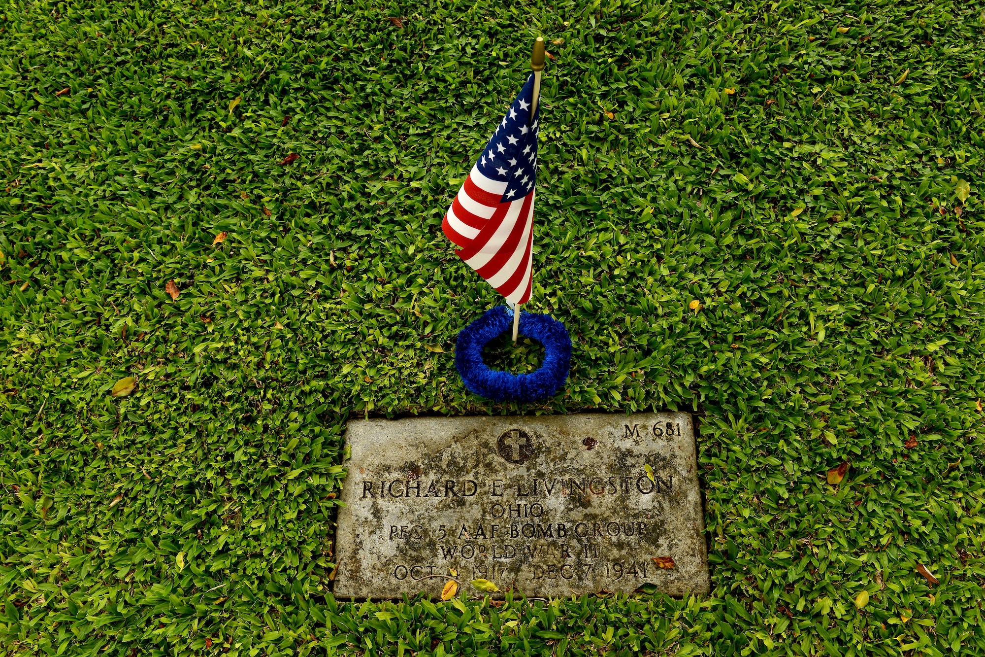 One of 92 flags and leis adorn gravesite of Army Air Forces Pfc. Richard E. Livingston, 5th Bomb Group, Hickam Field, at the National Cemetery of the Pacific, at Punchbowl in Honolulu, to honor of his sacrifice as he was killed during the Dec. 7, 1941, attacks on Oahu.  Jessie Higa, volunteer historian and president of the Hickam History Club, directed a team of volunteers Dec. 2, 2012, to honor the men who were killed on that infamous day. Higa and a team of teenagers from a local school started placing flags last year as a community service project. (U.S. Air Force photo/Staff Sgt. Mike Meares)