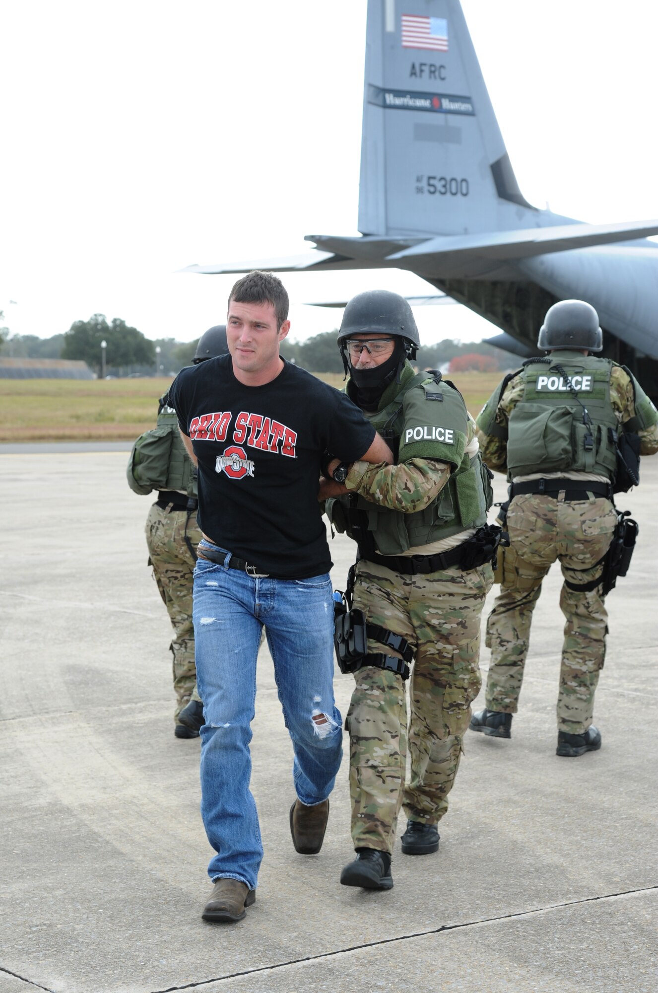 Staff Sgt. Cody Spitler, 81st Force Support Squadron, portrays a hostage who is being apprehended for safety purposes by the Biloxi Police Department Special Response Team upon his release from the aircraft during an anti-hijacking exercise on the flightline at Keesler Air Force Base, Miss., Dec. 4, 2012. The exercise scenario consisted of a disgruntled Airman, who after being denied leave during the holidays, created a fake Air Force leave form to get on a flight and hijack the aircraft to fly home.  (U.S. Air Force photo by Kemberly Groue)