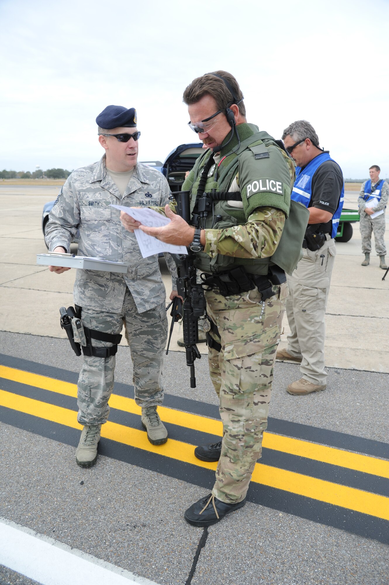 Master Sgt. Michael Smith, 81st Security Forces Squadron, and Officer Scott Doucet, the Biloxi Police Department Special Response Team commander, discuss the integration of Doucet’s officers into the base’s response to the hijacking simulation by providing an explanation of the team’s capabilities during an anti-hijacking exercise on the flightline at Keesler Air Force Base, Miss., Dec. 4, 2012. The exercise scenario consisted of a disgruntled Airman, who after being denied leave during the holidays, created a fake Air Force leave form to get on a flight and hijack the aircraft to fly home.  (U.S. Air Force photo by Kemberly Groue)