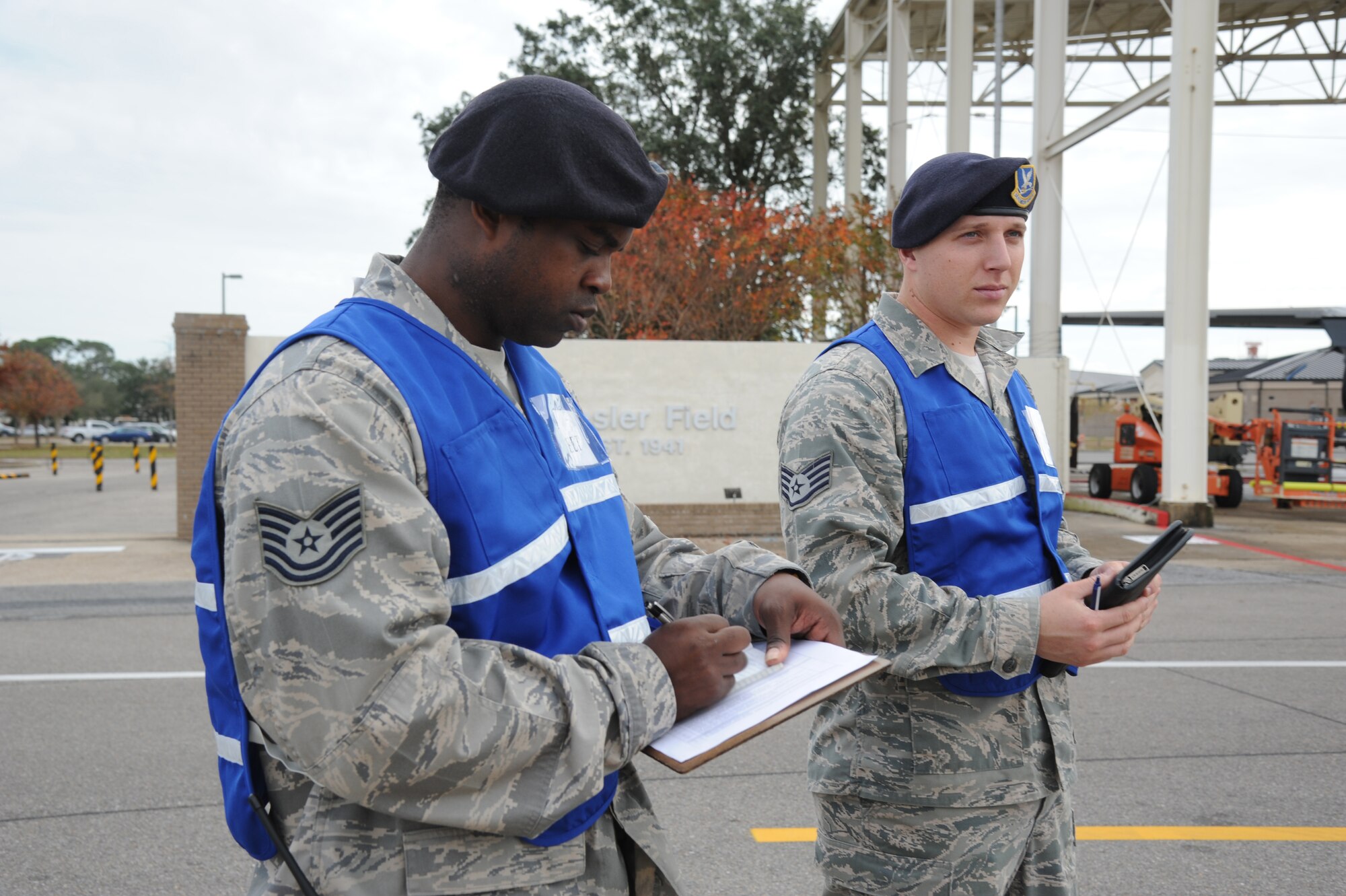 Tech. Sgt. Jason Gavin and Staff Sgt. Jeffery Fitzgerald, 81st Security Forces Squadron exercise evaluation team members, make time line notes as an anti-hijacking exercise gets under way Dec. 4, 2012, on the flightline at Keesler Air Force Base, Miss.  The exercise scenario consisted of a disgruntled Airman, who after being denied leave during the holidays, created a fake Air Force leave form to get on a flight and hijack the aircraft to fly home.  (U.S. Air Force photo by Kemberly Groue)