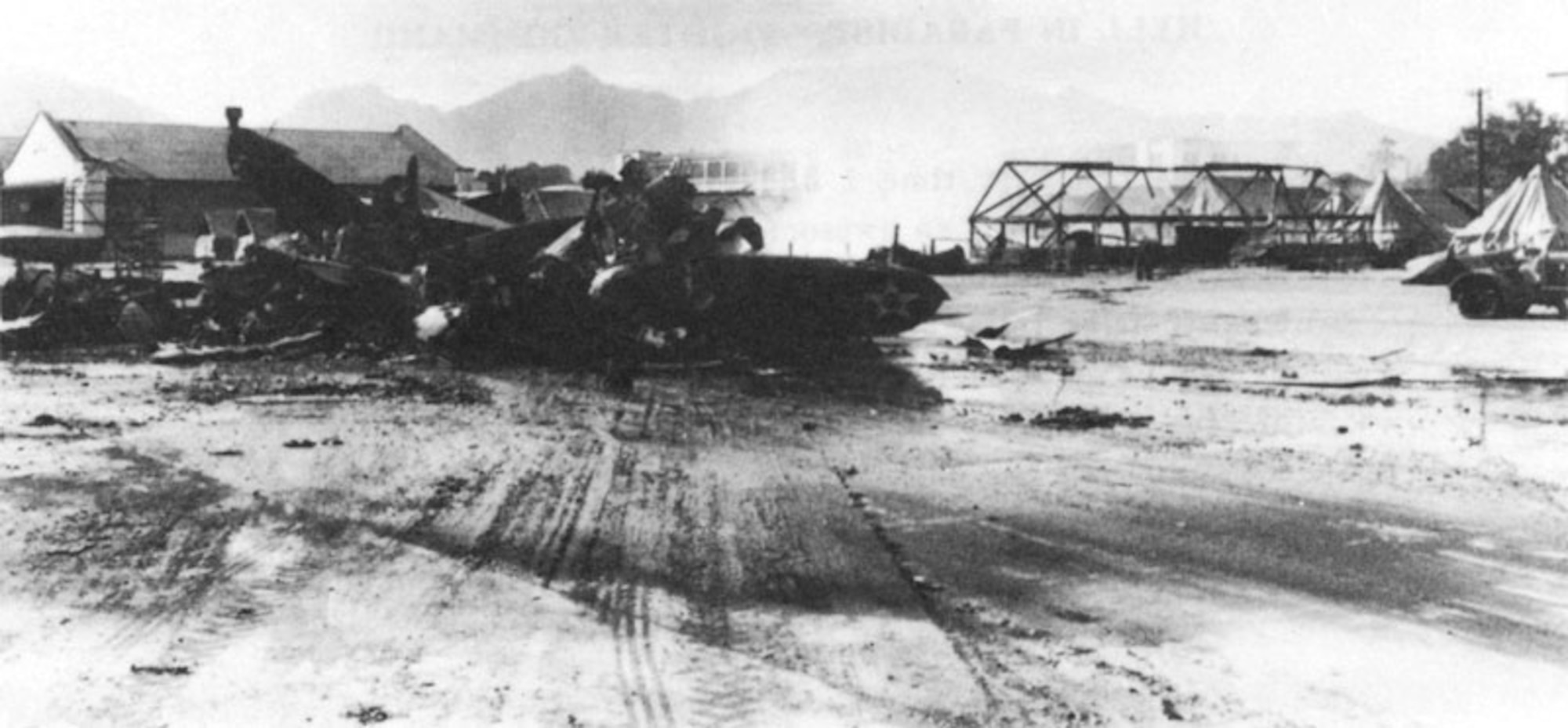 Wrecked planes on Wheeler Air Field flight line, with Hangar 2 in background and (on the right) tent quarters where many enlisted men were killed Dec. 7, 1941. 