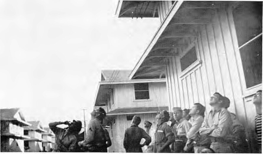 Members of the Hawaiian Air Force's Headquarters Squadron, 17th Tow Target Squadron and 23d Materiel Squadron watch Japanese high-Ievel horizontal bombers heading toward Pearl Harbor Dec. 7, 1941. (John W. Wilson)  