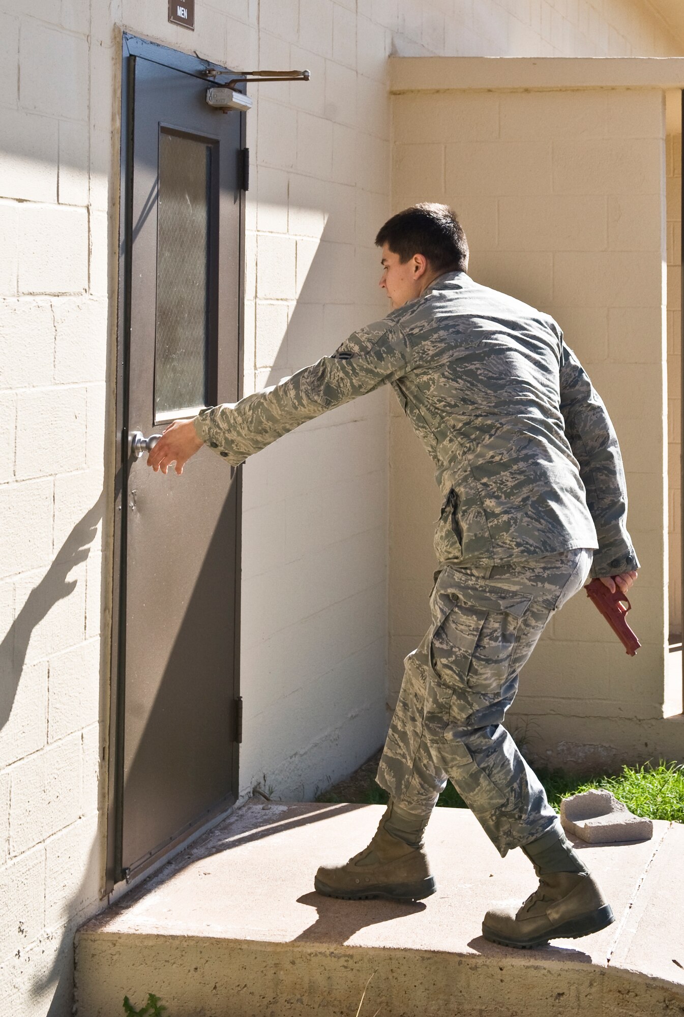 Senior Airman Andre Vasquez, 7th Civil Engineer Squadron, attempts to enter a squadron building during an active-shooter exercise, Nov. 28, 2012, at Dyess Air Force Base, Texas. Throughout the week, squadrons across the base were randomly targeted as a “disgruntled” Airman within each unit simulated being engaged in killing or attempting to kill people within their areas. (U.S. Air Force photo by Airman 1st Class Peter Thompson/ Released)
