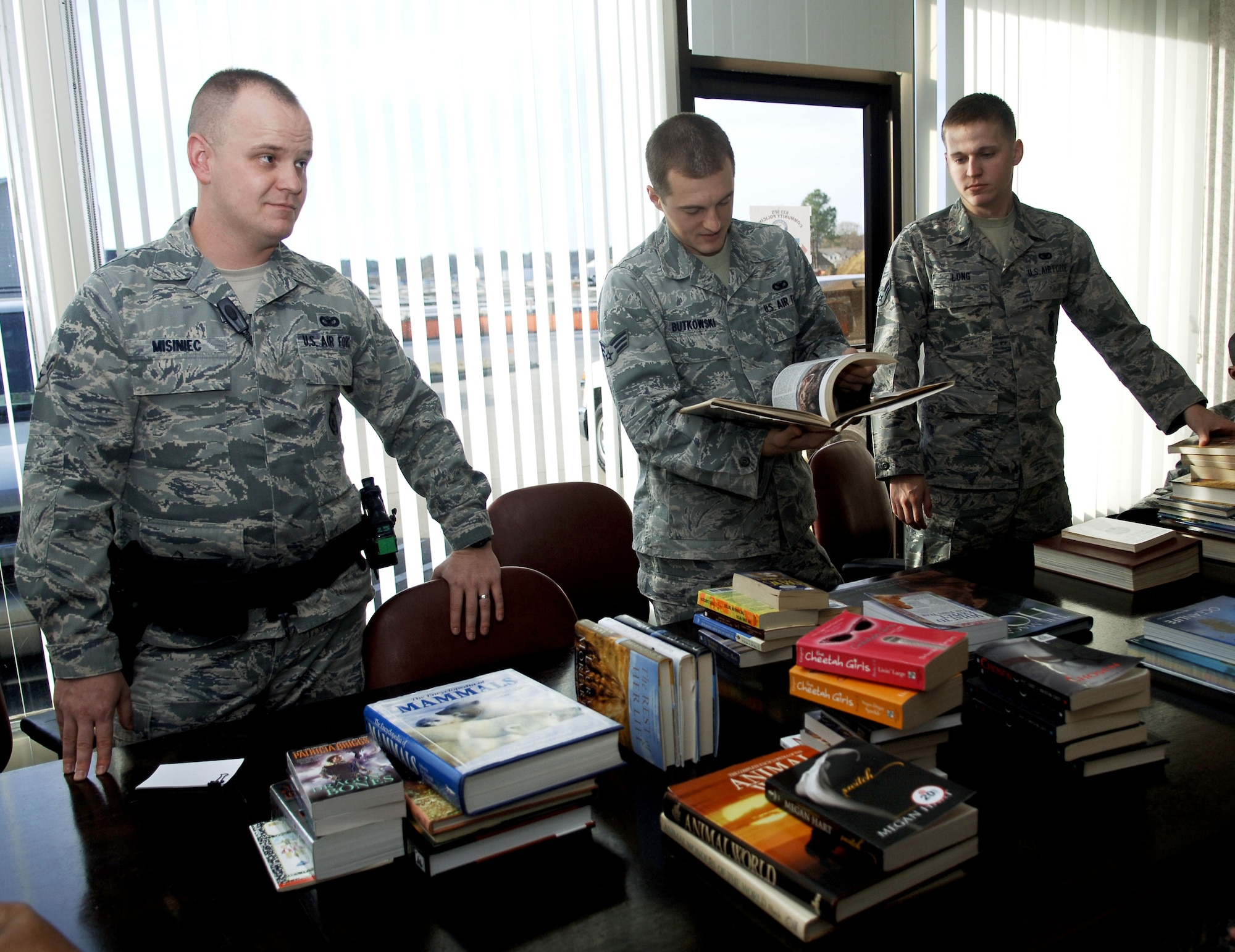 Members of the 633rd Security Forces Squadron community policing section sort through books collected from their coat and book drive, Nov. 30, 2012, at Langley Air Force Base, Va.  More than 200 books and magazines were collected to be donated to local schools and the U.S.O. (U.S. Air Force photo by Staff Sgt. Katie Gar Ward / Released)