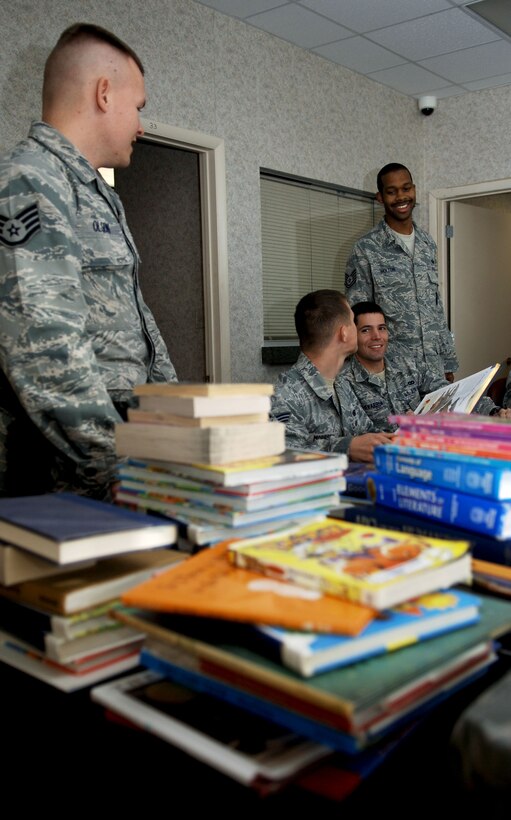 Members of the 633rd Security Forces Squadron community policing section sort through books collected from their coat and book drive, Nov. 30, 2012, at Langley Air Force Base, Va.   Staff Sgt. Justin Olsen, 633rd SFS community policing patrolman, who headed the 2012 drive, said this was their most successful year.  (U.S. Air Force photo by Staff Sgt. Katie Gar Ward / Released)
