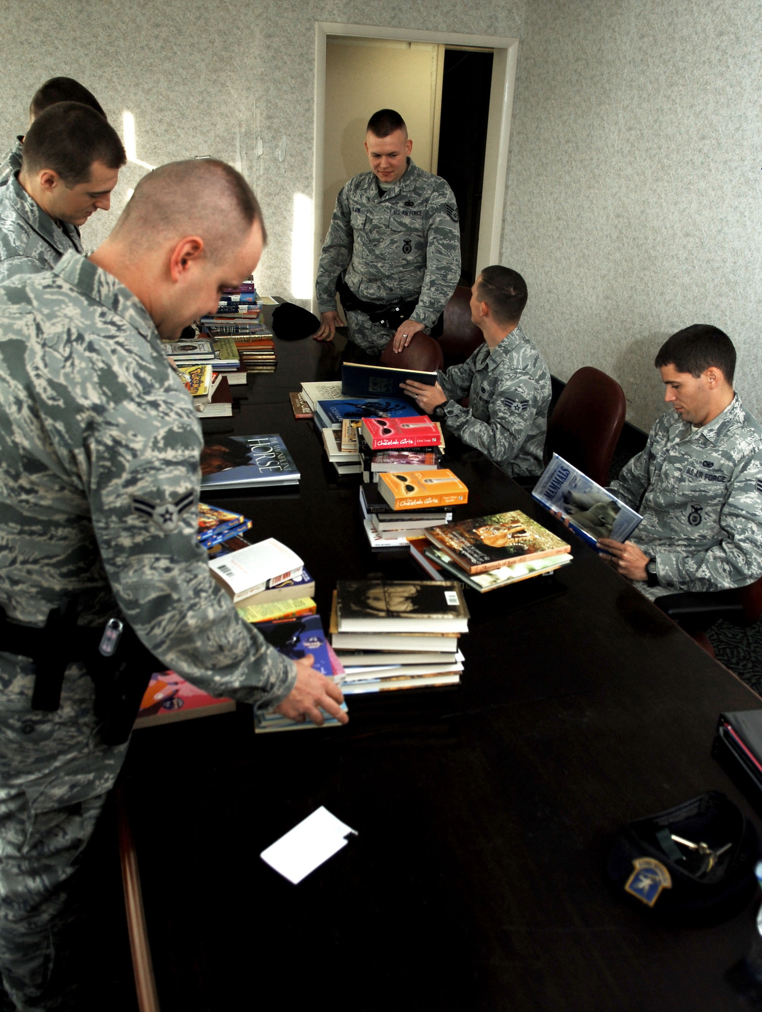 Members of the 633rd Security Forces Squadron community policing section sort through books collected from their coat and book drive, Nov. 30, 2012, at Langley Air Force Base, Va.   The drive lasted collectively from Oct. 1 through Nov. 30, and garnered more than 400 items to benefit Hampton Roads Ecumenical Lodgings and Provision, or “H.E.L.P,” Incorporated, as well as local schools.   (U.S. Air Force photo by Staff Sgt. Katie Gar Ward / Released)