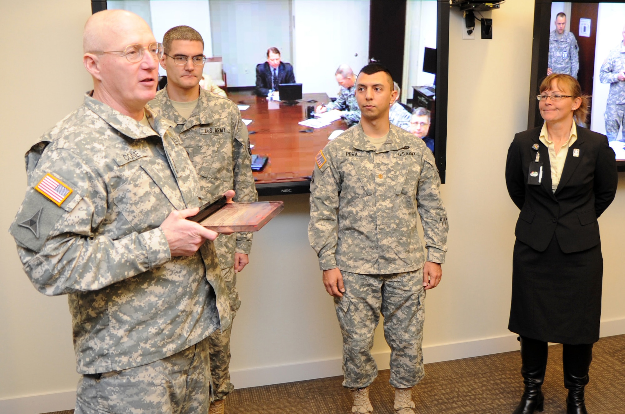 U.S. Army Gen. Robert W. Cone, commanding general of the U.S. Army Training and Doctrine Command, presents the Director of Safety Composite Risk Management Award to Sgt. 1st Class Randolph E. Hagin, TRADOC Band safety and security noncommissioned officer in charge, while Maj. Leonel A. Pena, TRADOC Band commander, as Susan M. George, TRADOC safety officer, look on at TRADOC Headquarters at Fort Eustis, Va., Dec. 3, 2012. Cone congratulated the band on its yearlong run of no Class A safety violations. (U.S. Army photo by Steven
Schneider/Released)