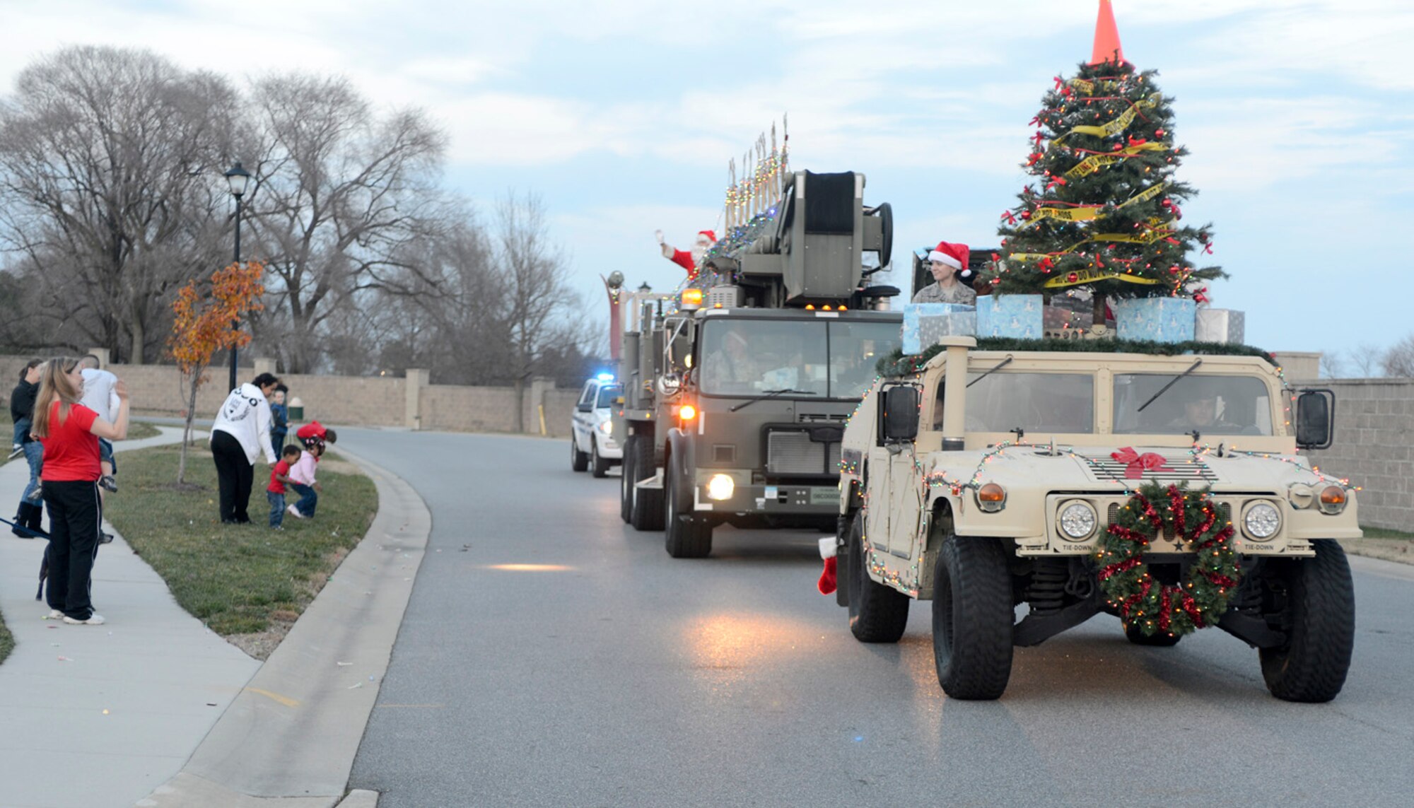 Santa Claus waves to spectators as two 436th Security Forces Squadron vehicles provide escort during the Christmas Parade Dec. 4, 2012, in base housing on Dover Air Force Base, Del. The Christmas Parade kicked off the holiday season on base and was followed by a tree lighting ceremony. (U.S. Air Force photo by Tech. Sgt. Chuck Walker)
