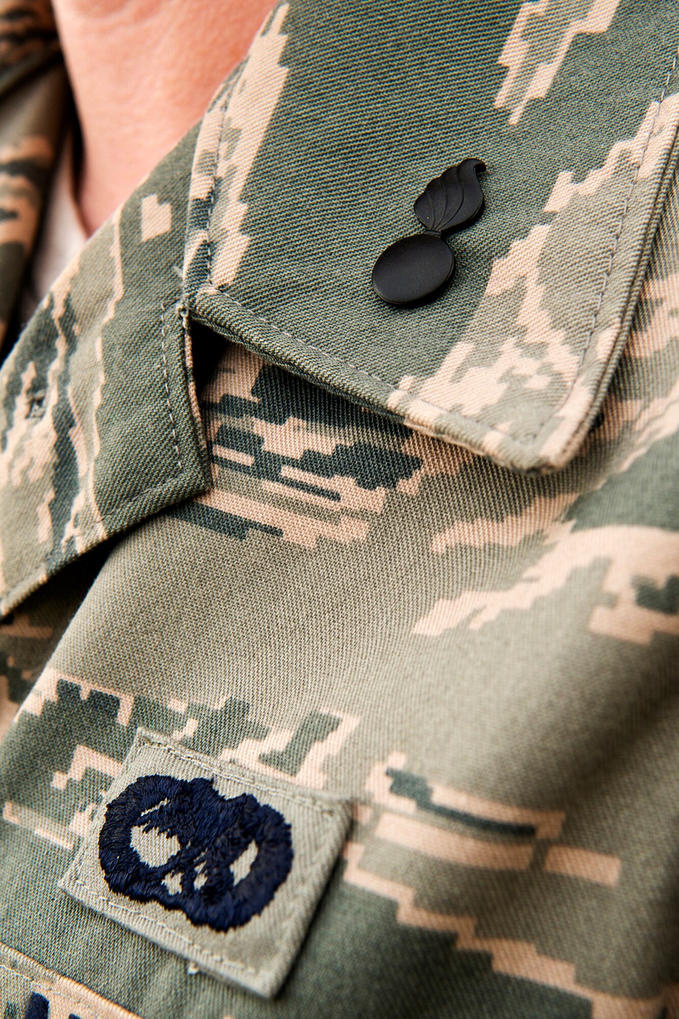 A munitions troop assigned to the 307th Maintenance Squadron proudly wears the AMMO "pitch pot" pin following a ceremony on Dec. 2, 2012, Barksdale Air Force Base, La. The pin is given to Airmen who earn upgrade to the 5-Skill Level, which is awarded after a period of on-the-job training and completion of the Career Development Course. (U.S. Air Force photo by Master Sgt. Greg Steele/Released)