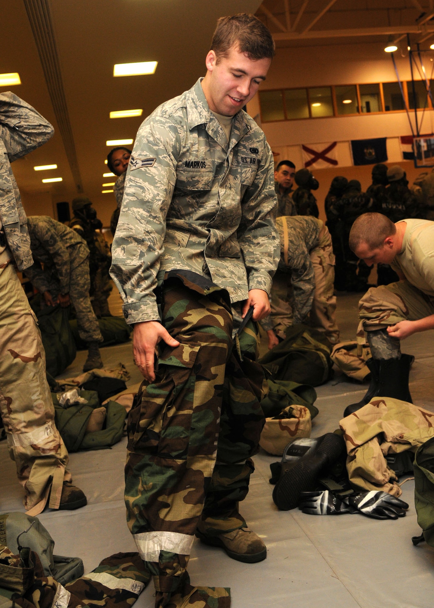 Airman 1st Class Stephen Markos, 100th Logistics Readiness Squadron fuels apprentice from Hoburt, Ind., puts on his mission-orientated protective posture gear pants as he prepares to go into MOPP level 2 during an exercise at the Ability to Survive and Operate Rodeo Dec. 5, 2012, in the Hardstand Fitness Center, at RAF Mildenhall, England. The Airman also had to perform self-aid buddy care during the rodeo. (U.S. Air Force photo by Airman 1st Class Kelsey Waters/Released)