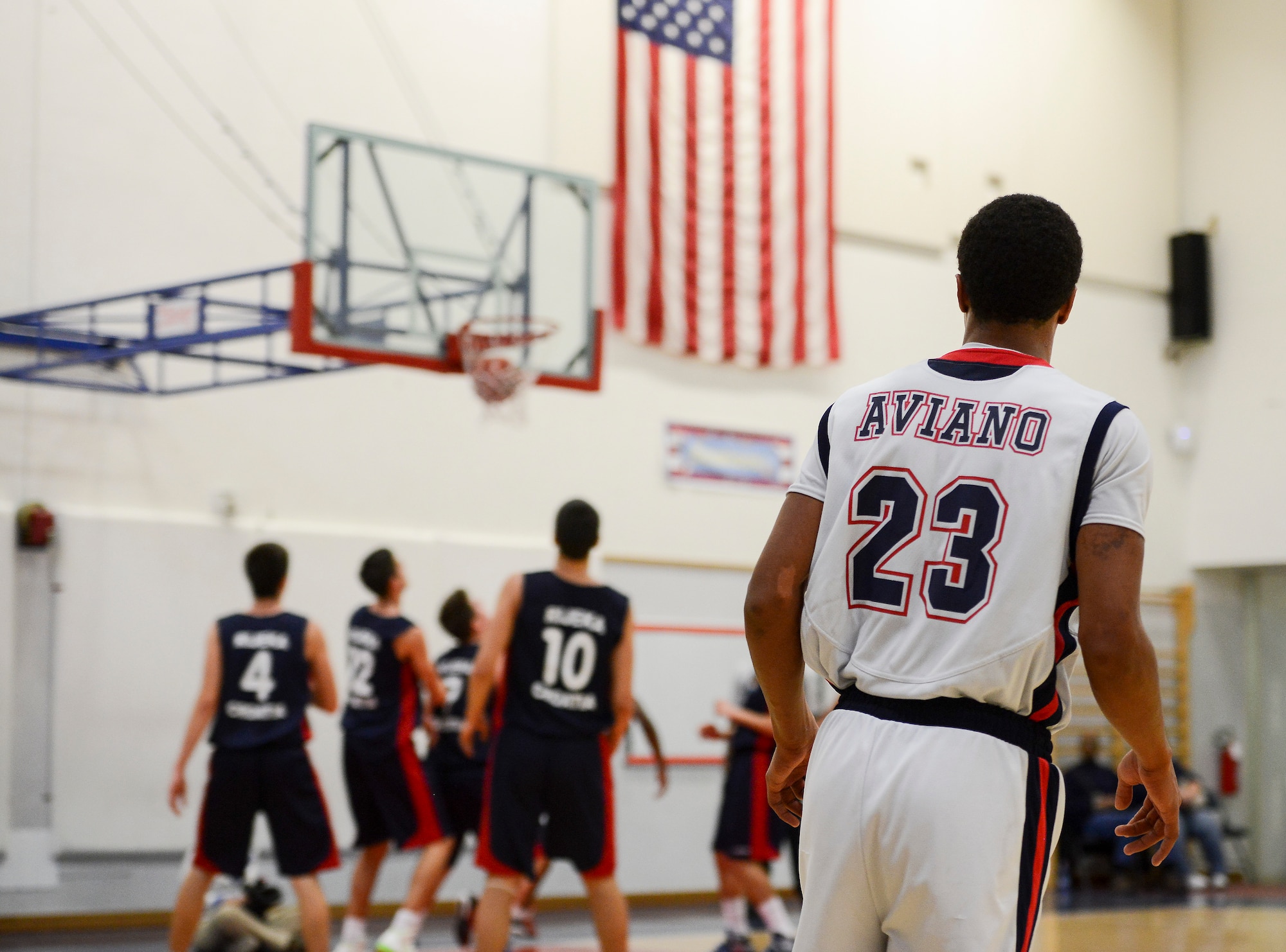 An Aviano High School basketball team member looks on as a point is scored by a Croatian player during a game Dec. 1 at Aviano Air Base, Italy. The Aviano basketball players and their families welcomed the Croatian team into their homes as part of a cultural exchange program. (U.S. Air Force photo by Senior Airman Katherine Tereyama)