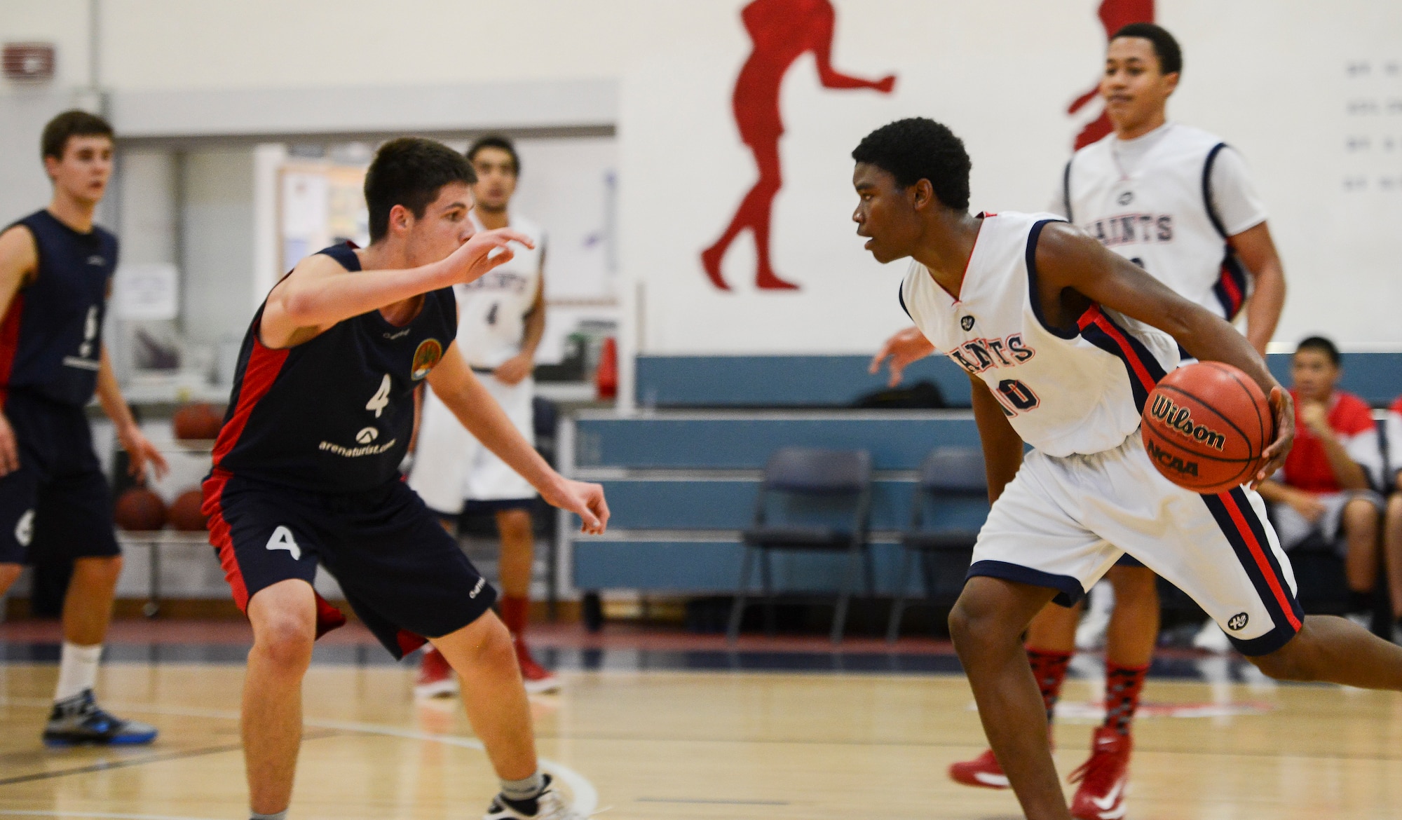 Elijah Smith, an Aviano High School senior, dribbles a basketball down the court during a game Dec. 1 at Aviano Air Base, Italy. The Aviano basketball players and their families welcomed the Croatian team into their homes as part of a cultural exchange program. (U.S. Air Force photo by Senior Airman Katherine Tereyama)