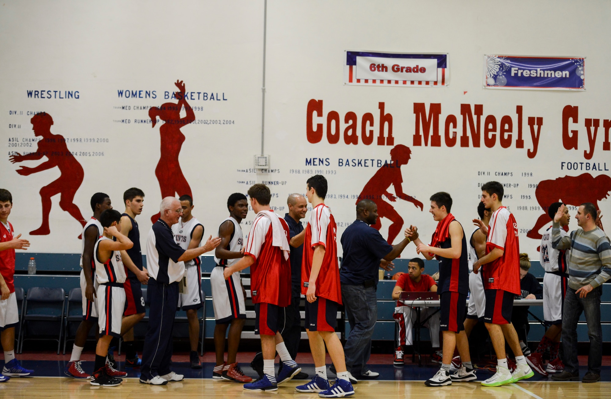 Aviano High School team members shake hands with their opponents from Rijeka, Croatia after a game Dec. 1 at Aviano Air Base, Italy. The Aviano basketball players and their families welcomed the Croatian team into their homes as part of a cultural exchange program. (U.S. Air Force photo by Senior Airman Katherine Tereyama)