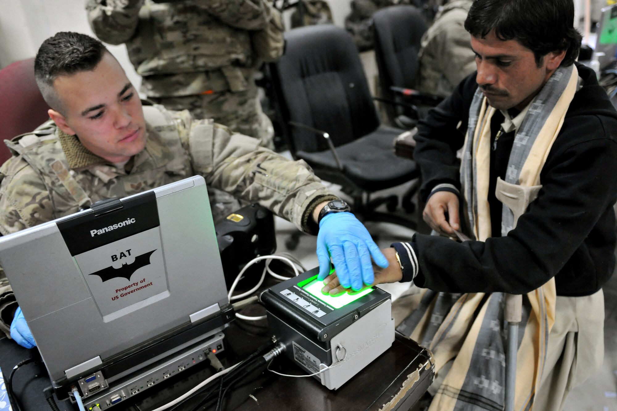 Staff Sgt. John Silvia, 455th Expeditionary Security Forces Group entry control point NCOIC, scans an Afghan man's fingerprints in the waiting area of the Korean Hospital at Bagram Airfield, Afghanistan, Dec. 2, 2012. Medical teams use biometrics to identify and track the records for all incoming patients by scanning their iris and fingerprints and then inputting the information into a database.  (U.S. Air Force photo/Senior Airman Chris Willis)