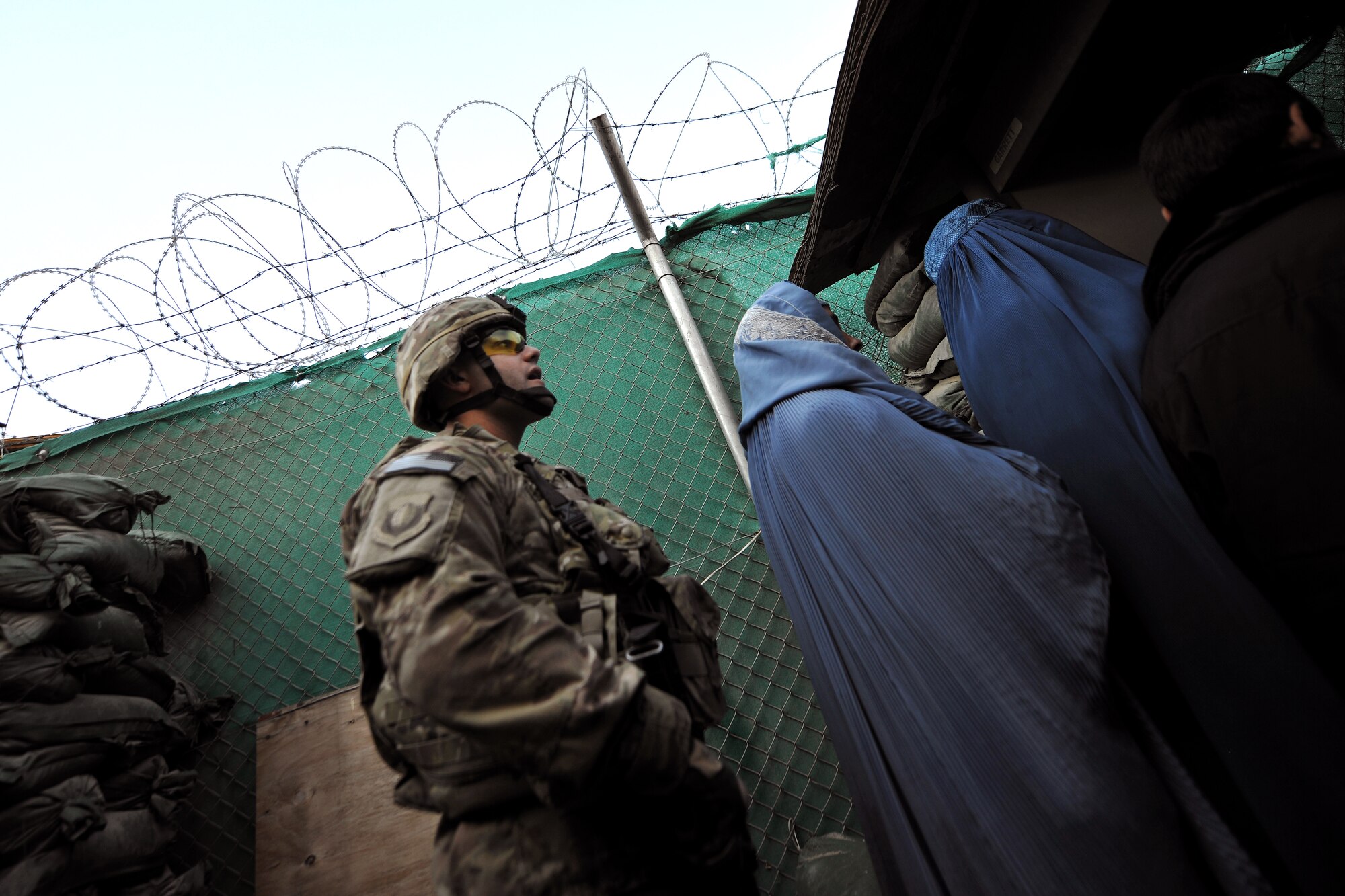 Master Sgt. Thomas Carpino, 455th Expeditionary Security Forces Group bravo sector superintendent, escorts local Afghan women inside the medical entry control point at Bagram Airfield, Afghanistan, Dec. 2, 2012.  The 455 EFSG and Afghan local guards provide security and collect biometrics to identify and track the records for all the incoming patients.  (U.S. Air Force photo/Senior Airman Chris Willis)