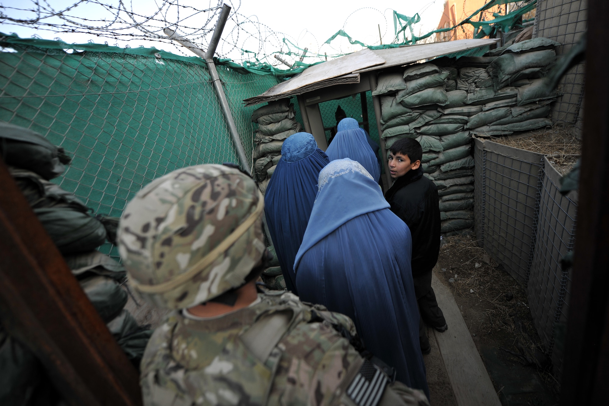 Master Sgt. Thomas Carpino, 455th Expeditionary Security Forces Group bravo sector superintendent, escorts local Afghan women inside the medical entry control point at Bagram Airfield, Afghanistan, Dec. 2, 2012.  The 455 EFSG and Afghan local guards provide security and collect biometrics to identify and track the records for all the incoming patients.  (U.S. Air Force photo/Senior Airman Chris Willis)