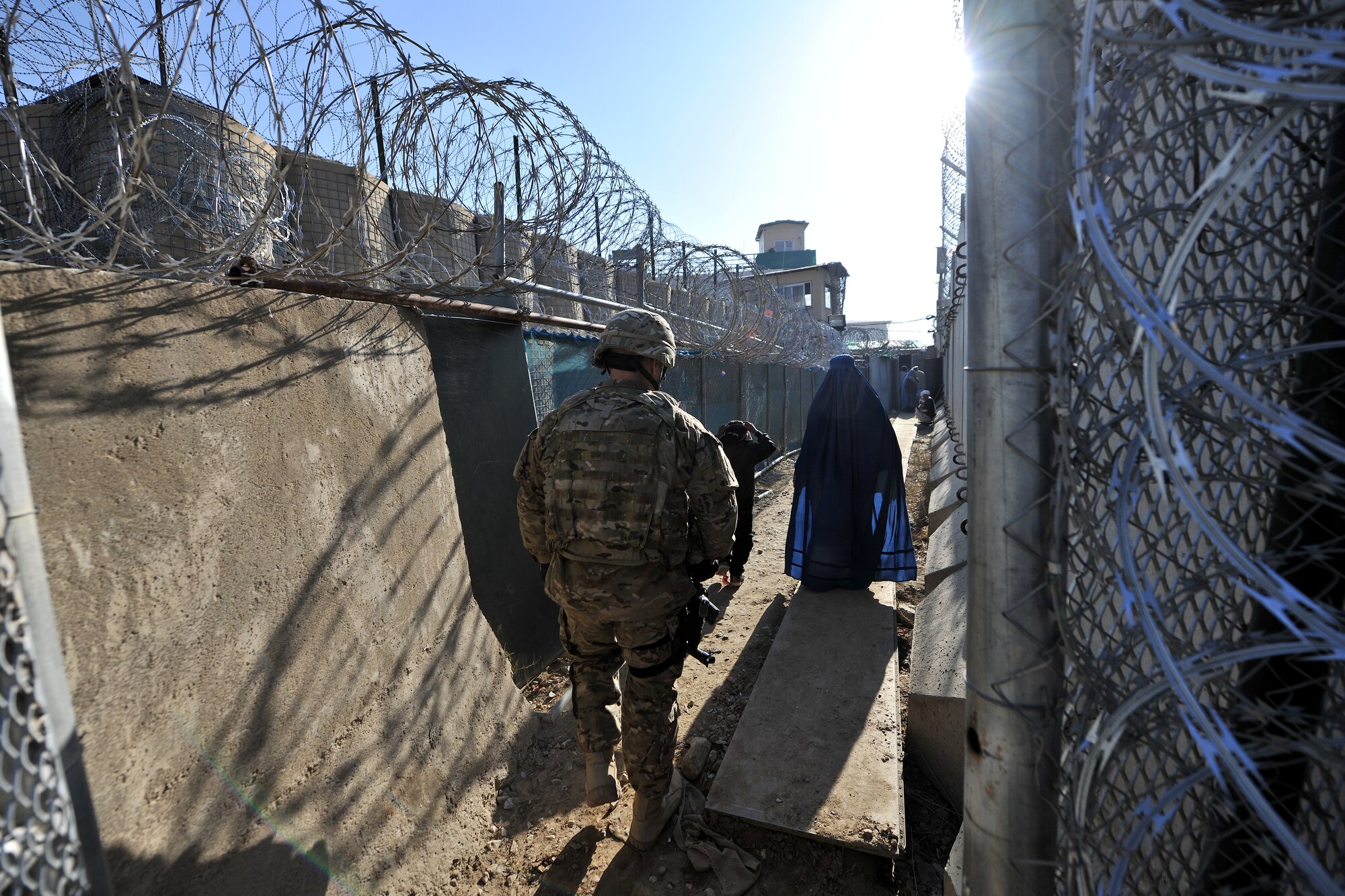 Master Sgt. Thomas Carpino, 455th Expeditionary Security Forces Group bravo sector superintendent, escorts local Afghan women inside the medical entry control point at Bagram Airfield, Afghanistan, Dec. 2, 2012.  The 455 EFSG and Afghan local guards provide security and collect biometrics to identify and track the records for all the incoming patients.  (U.S. Air Force photo/Senior Airman Chris Willis)