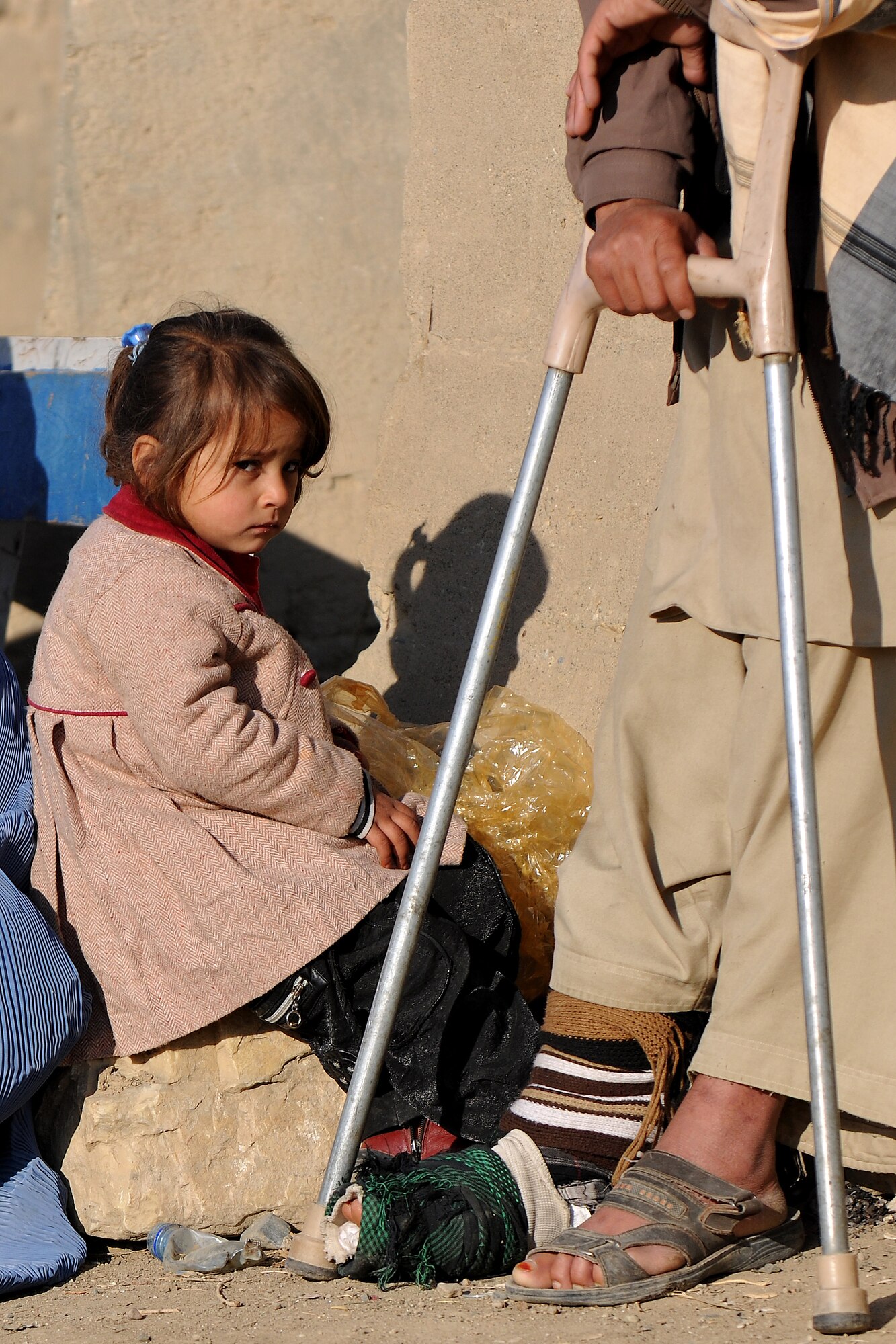 A local Afghan girl waits as her guardian begins his processing through the medical entry control point at Bagram Airfield, Afghanistan, Dec. 2, 2012.  455th Expeditionary Security Forces Group entry control point Airmen and Afghan local guards provide security and collect information to identify and track records for all incoming patients.  (U.S. Air Force photo/Senior Airman Chris Willis)