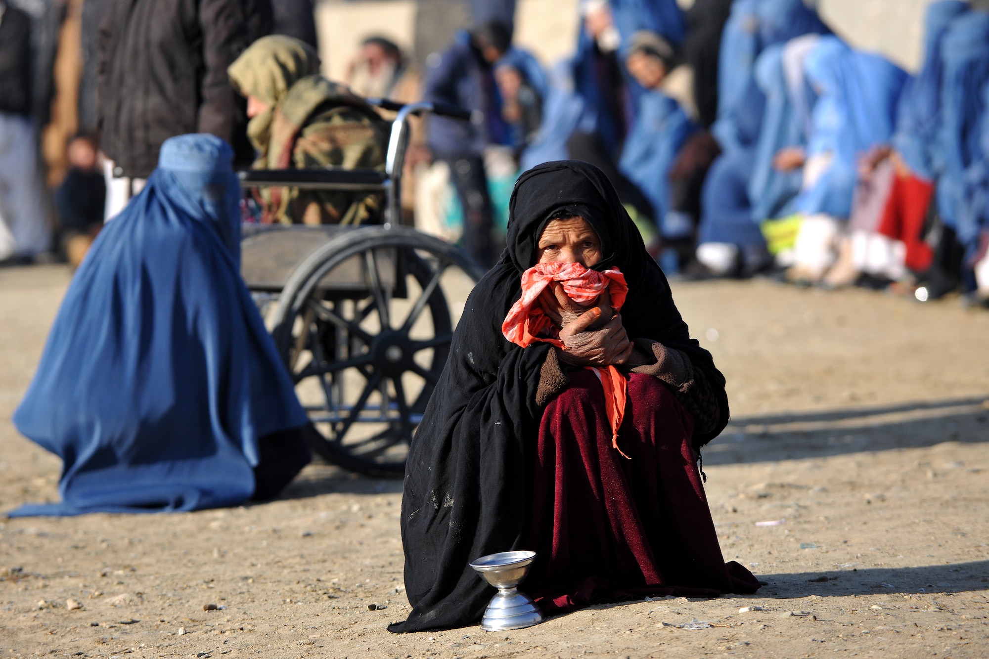 An Afghan woman and several other locals await care at the Korean Hospital located on Bagram Airfield, Afghanistan, Dec. 2, 2012. The 455th Expeditionary Security Forces Group bravo sector and Afghan local guards provide security for hospital patients receiving free basic medical care.  (U.S. Air Force photo/Senior Airman Chris Willis)