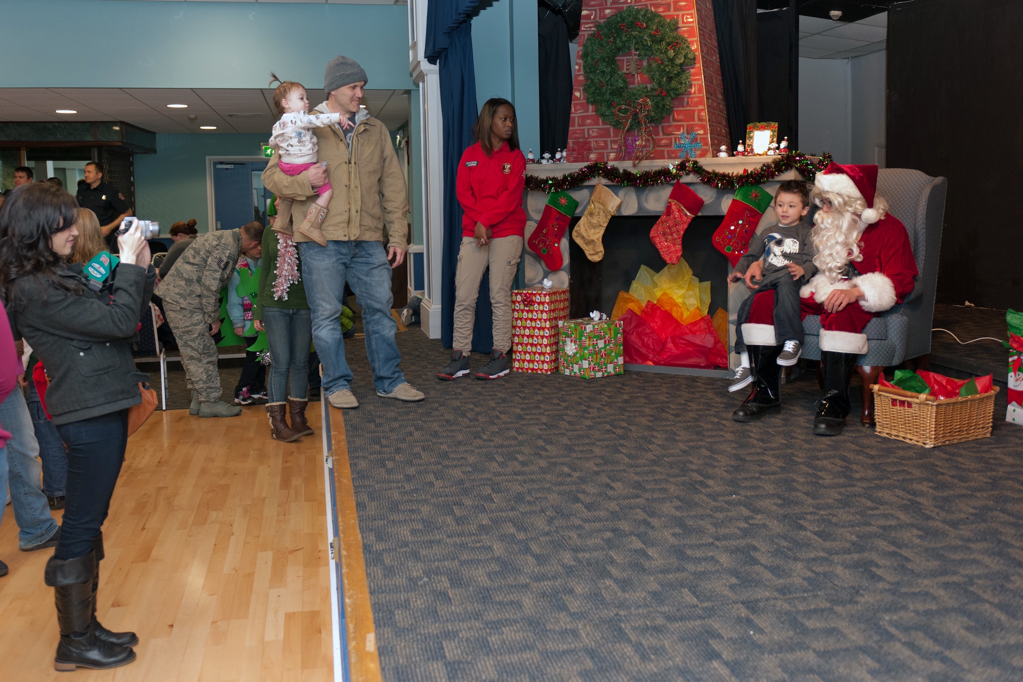 RAF ALCONBURY, United Kingdom – Parents take pictures of their children with Santa at Santa’s Grotto in the Community Activities Center Dec. 1. More than 100 people turned out for the Holiday Parade, Santa’s Grotto, and Christmas Tree and Menorah Lighting Ceremony held at the RAF Alconbury Chapel. (U.S. Air Force photo by Staff Sgt. Brian Stives)