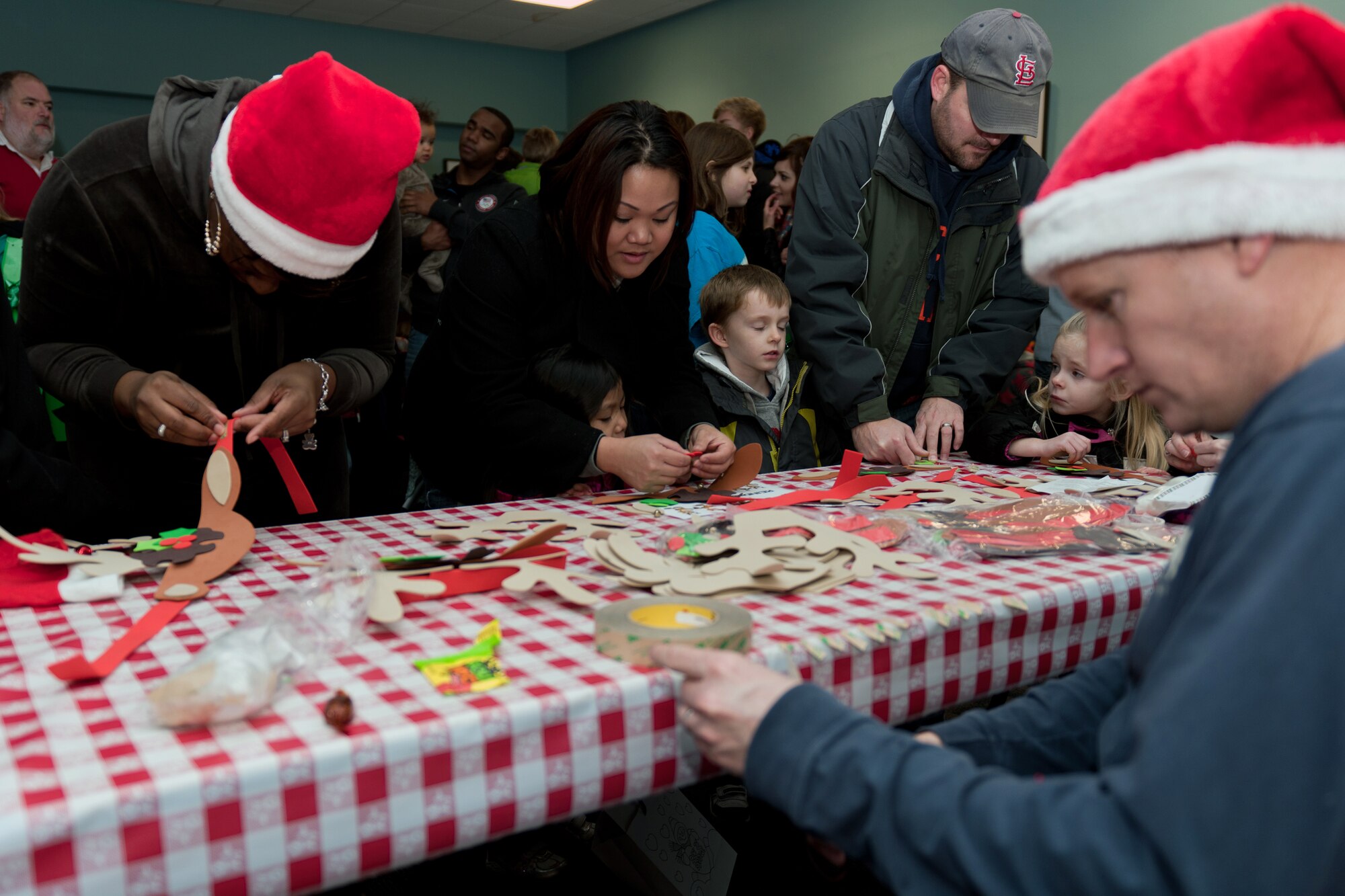 RAF ALCONBURY, United Kingdom – With the help of their parents, children from RAF Alconbury and the local community make reindeer hats at one of the many arts and crafts tables set up at Santa’s Grotto in the Community Activities Center Dec. 1. More than 100 people turned out for the Holiday Parade, Santa’s Grotto, and Christmas Tree and Menorah Lighting Ceremony held at the RAF Alconbury Chapel. (U.S. Air Force photo by Staff Sgt. Brian Stives)