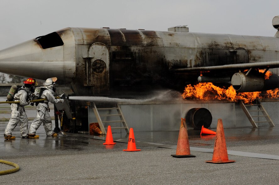 Firefighters with Kadena Fire Emergency Services put out a simulated aircraft fire on Kadena Air Base, Japan, Dec. 4, 2012. More than 15 firefighters were tasked with putting out simulated exterior fires, followed by entering the aircraft and fighting interior fires. Not only did Kadena firefighters train on aircraft fire scenarios, but they also trained on structural fire scenarios as part of their annual firefighter training. (U.S. Air Force photo/Airman 1st Class Hailey R. Davis)