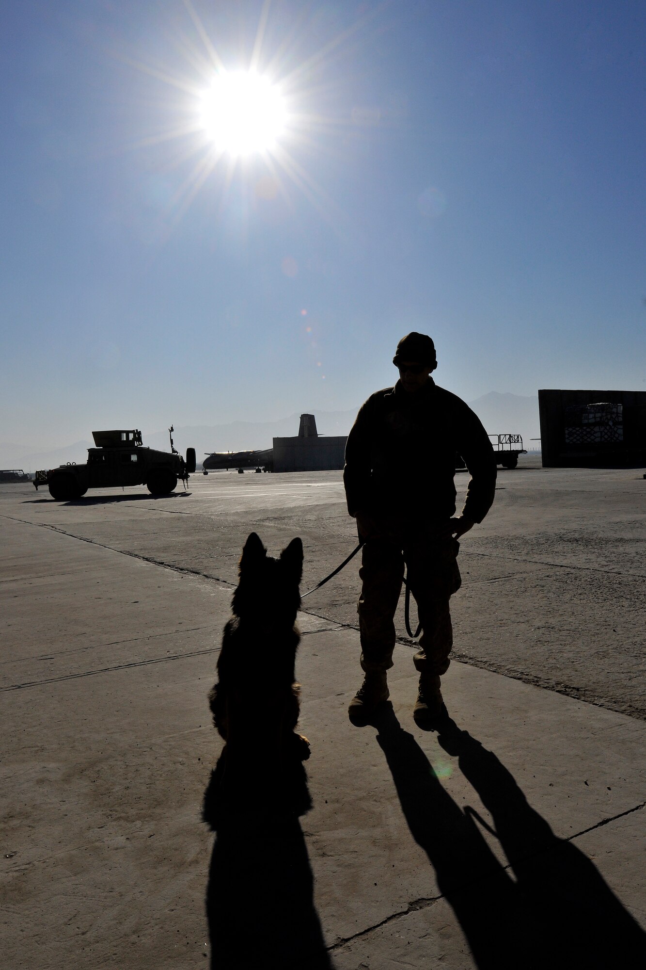 Staff Sgt. Mark Sidle, 455th Expeditionary Security Forces Group dog handler, and his dog, Arco, stand guard at an entry control point at Bagram Airfield, Afghanistan, Dec. 1, 2012.  The 455 SFG military working dog handlers work side by side with their dogs, searching vehicles for illegal drugs and explosives. (U.S. Air Force photo/Senior Airman Chris Willis)