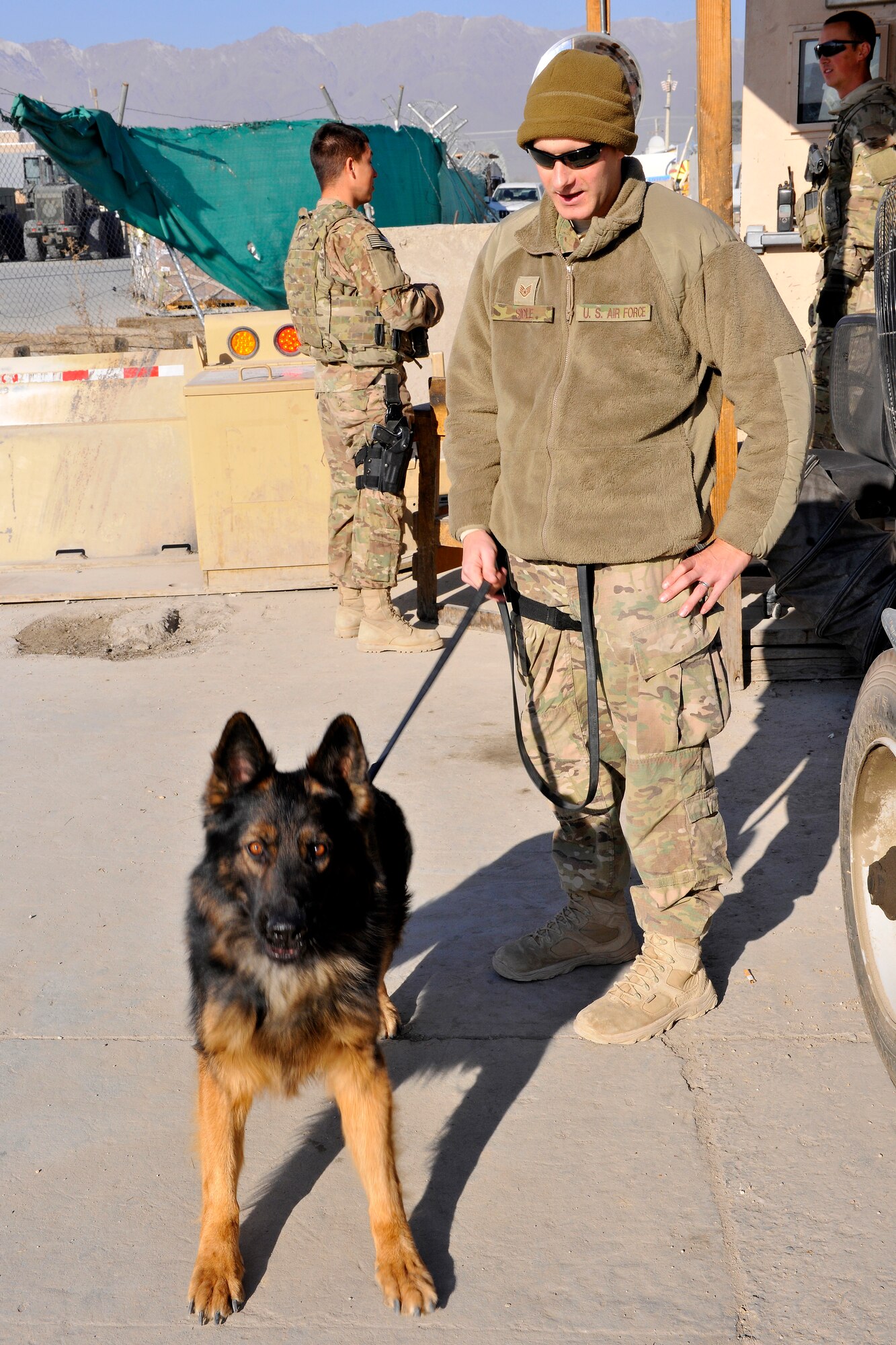 Staff Sgt. Mark Sidle, 455th Expeditionary Security Forces Group dog handler, and his dog, Arco, patrol an entry control point at Bagram Airfield, Afghanistan, Dec. 1, 2012.  This is 3-year-old Arco’s first deployment and Sidle’s second downrange. Both are deployed from Ellsworth Air Force Base, S.D.  (U.S. Air Force photo/Senior Airman Chris Willis) 