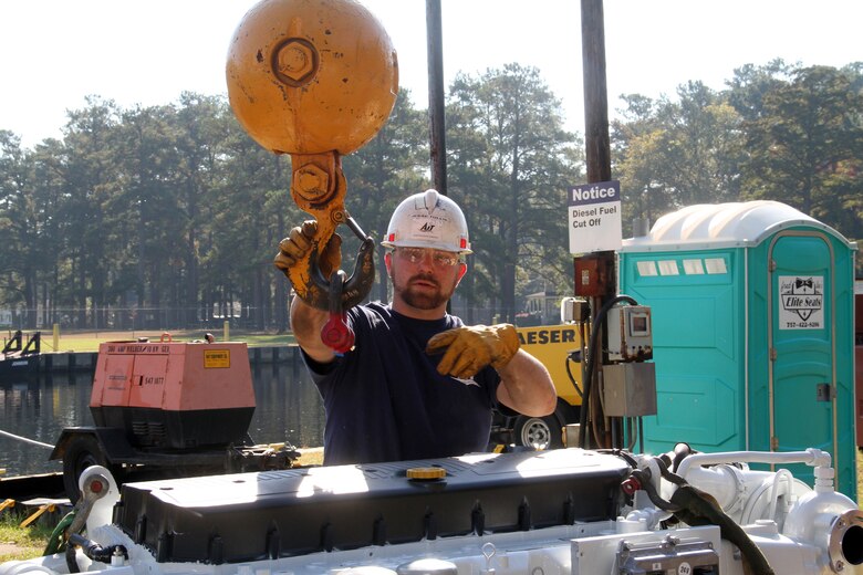 Contractor Jesse Lynn Tullis of Advanced Integrated Tech prepares to attach the wiring for the Iveco marine propulsion diesel engine to the derrick boat Elizabeth's Mantis hydraulic crane. Once the crane lifts, the engine is lowered in the Corps vessel's engine room. On Oct. 9, the Norfolk District, U.S. Army Corps of Engineers derrick boat Elizabeth's "green initiative" transformation began with the installation of two new fuel-efficient and EPA-compliant marine propulsion diesel engines. The project includes two companion diesel generators, housed in sound-barrier boxes that significantly reduce noise pollution and exhaust emissions. The eco-friendly engines have a 25-year life span.