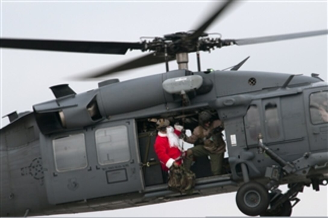 U.S. Air Force Tech. Sgt. Mike Morrison prepares North Pole native Santa Claus to be lowered to the ground from an HH-60G Pave Hawk at Royal Air Force Lakenheath, England, on Dec. 1, 2012.  Claus teamed up with the 56th Rescue Squadron to bring Christmas cheer to Hangar 7 where children were able to meet him and tell him what they wanted for Christmas.   