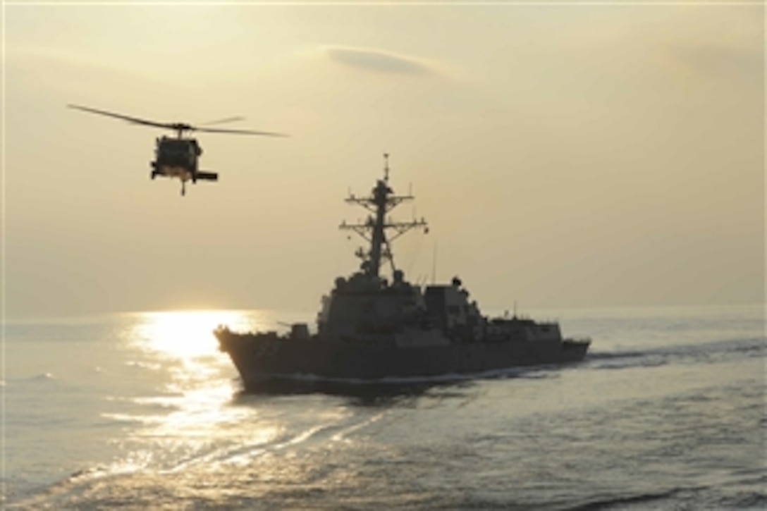 An MH-60S Knighthawk flies by the guided-missile destroyer USS Farragut (DDG 99) during a replenishment-at-sea evolution in the Arabian Sea on Dec. 4, 2012.  The Knighthawk is attached to Helicopter Sea Combat Squadron 8 and is assigned to the Military Sealift Command USNS Bridge (T-AOE 10).  